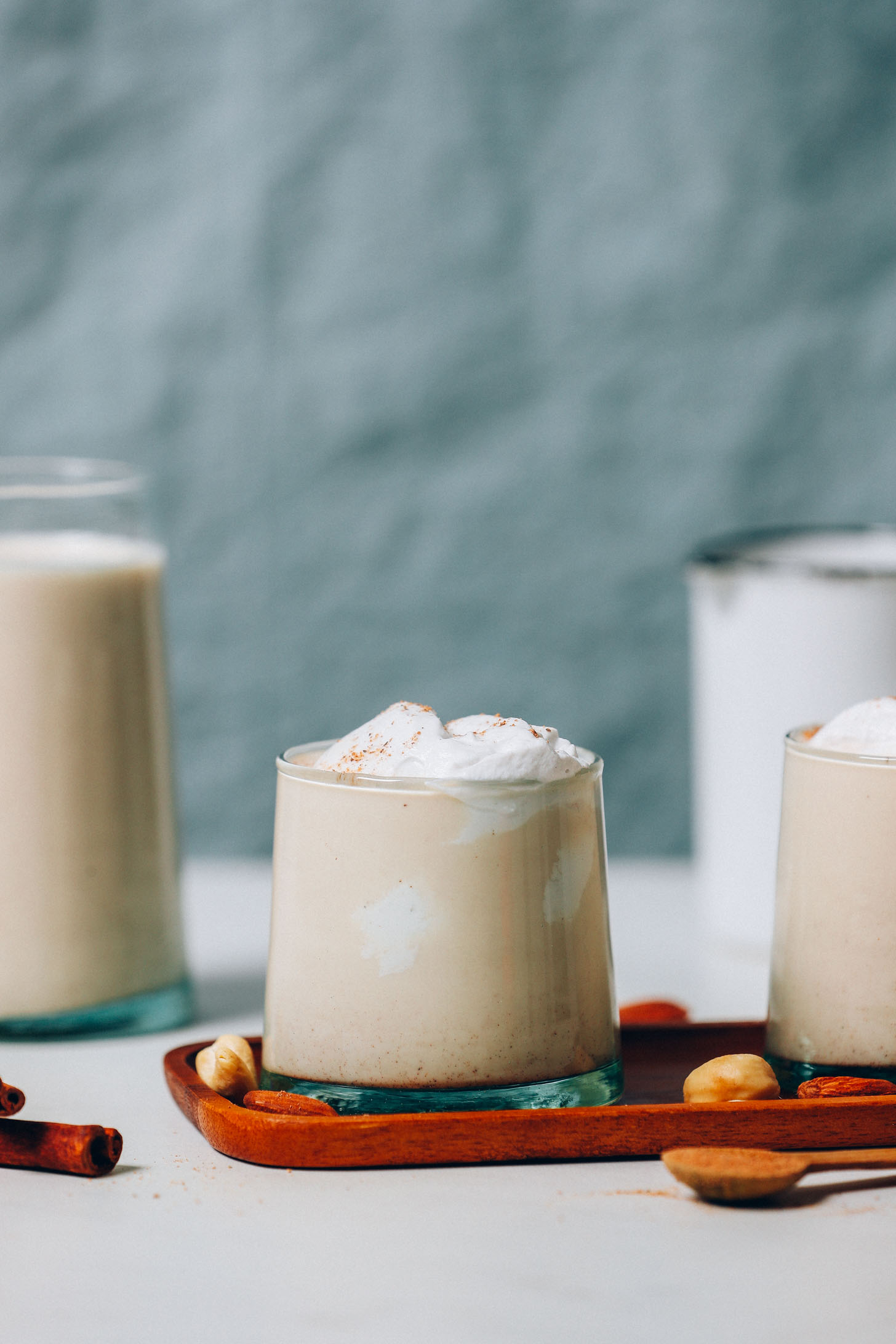 Glasses of Easy Vegan Eggnog topped with coconut whipped cream