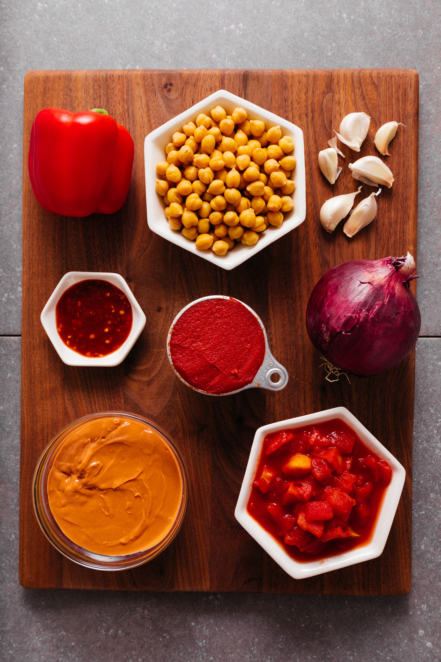 Wood cutting board with ingredients for making our easy Chickpea Tomato Peanut Stew recipe