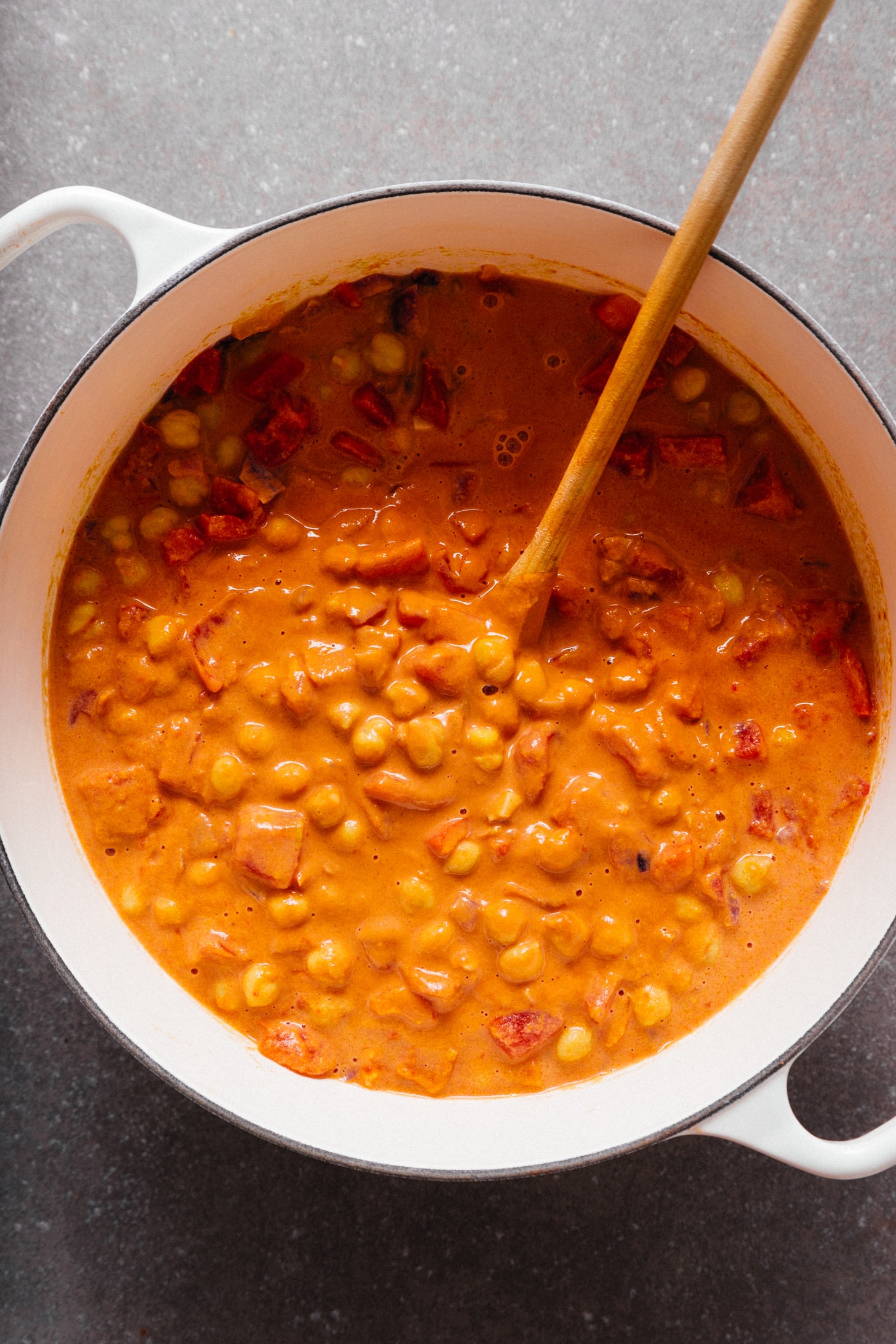 Wooden spoon in a pot of our Chickpea Tomato Peanut Stew recipe