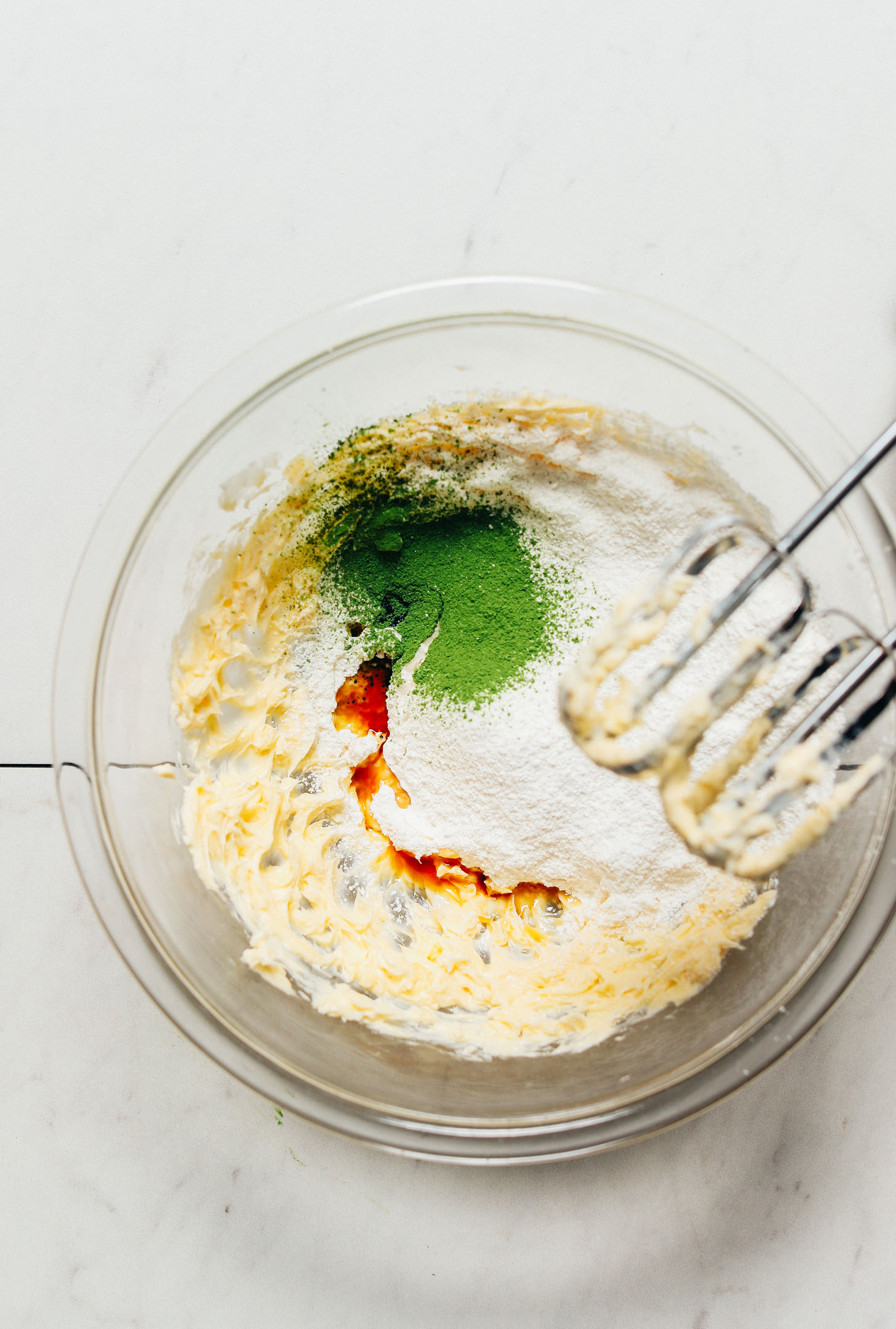 Mixing blades over a bowl of Matcha Buttercream Frosting