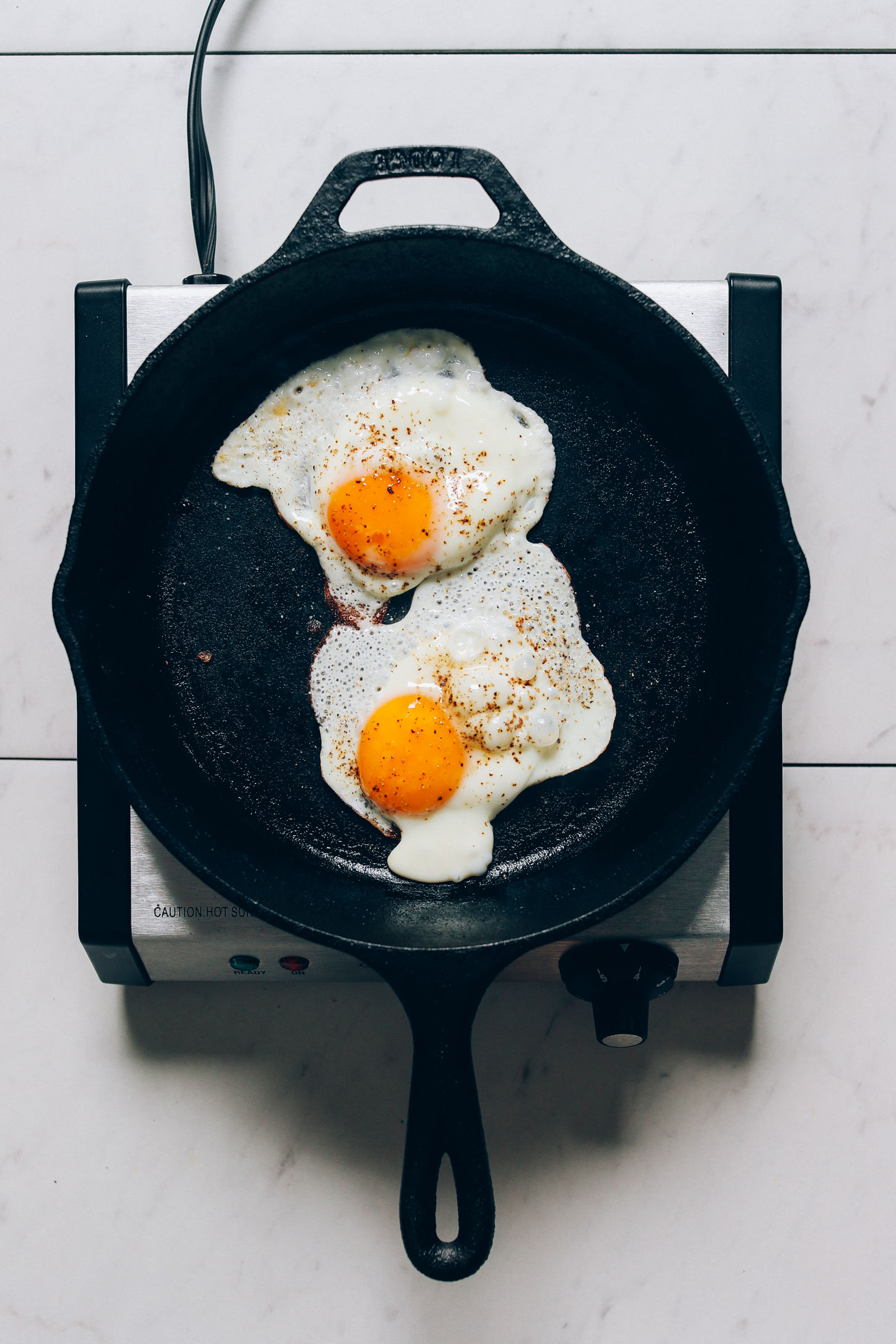 Skillet with two perfectly cooked sunny side up eggs