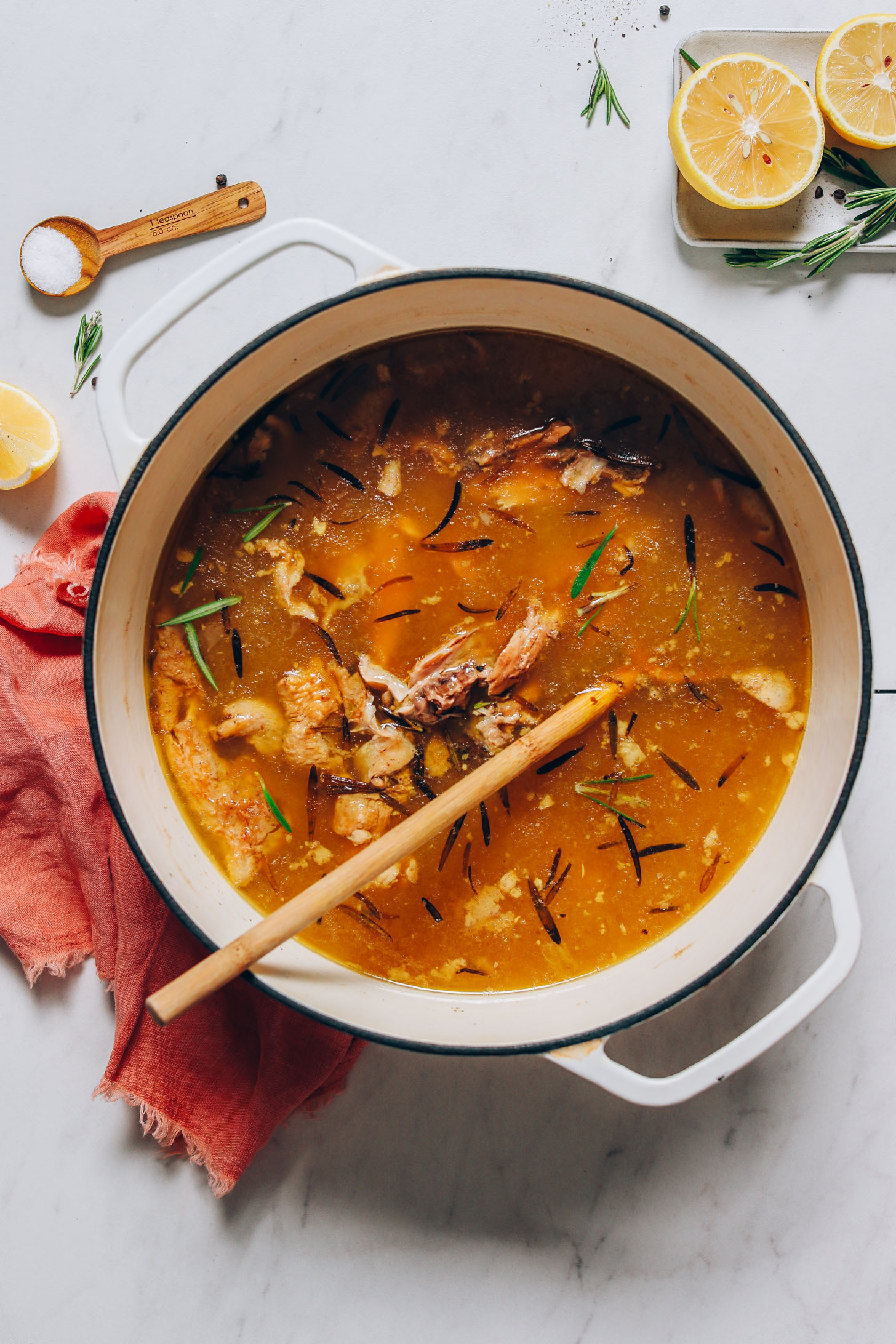 Dutch oven with a chicken carcass, water, and herbs for making our homemade Chicken Bone Broth recipe