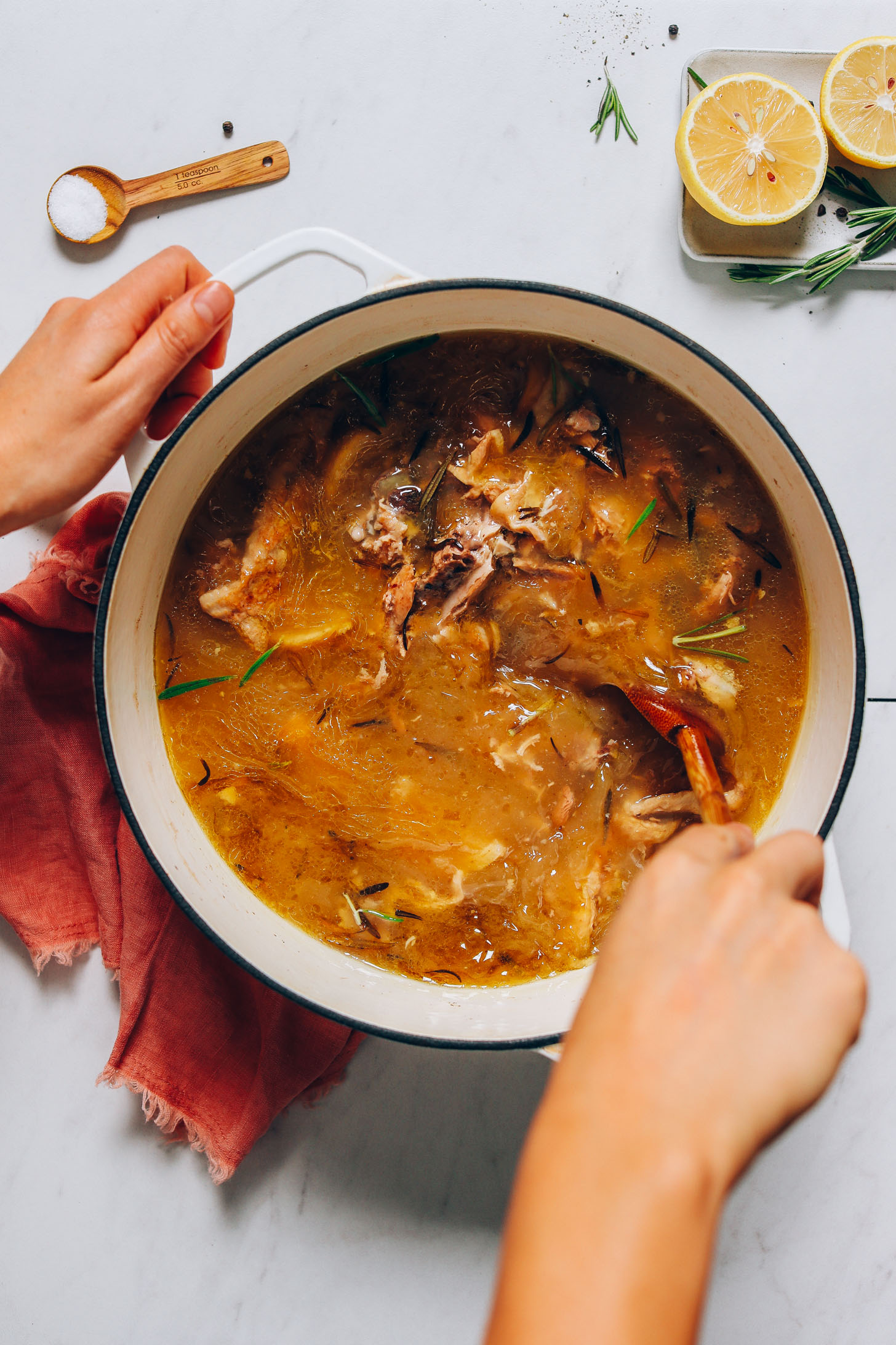 Using a wooden spoon to stir a pot of Homemade Bone Broth