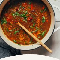 Wooden spoon in a pot of our Spiced Sweet Potato Lentil Soup recipe