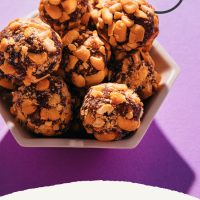 Bowl of homemade vegan candies with text saying 2-Ingredient Vegan PayDay Bites