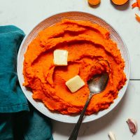 Bowl of Fluffy Mashed Sweet Potatoes and Carrots with slices of vegan butter