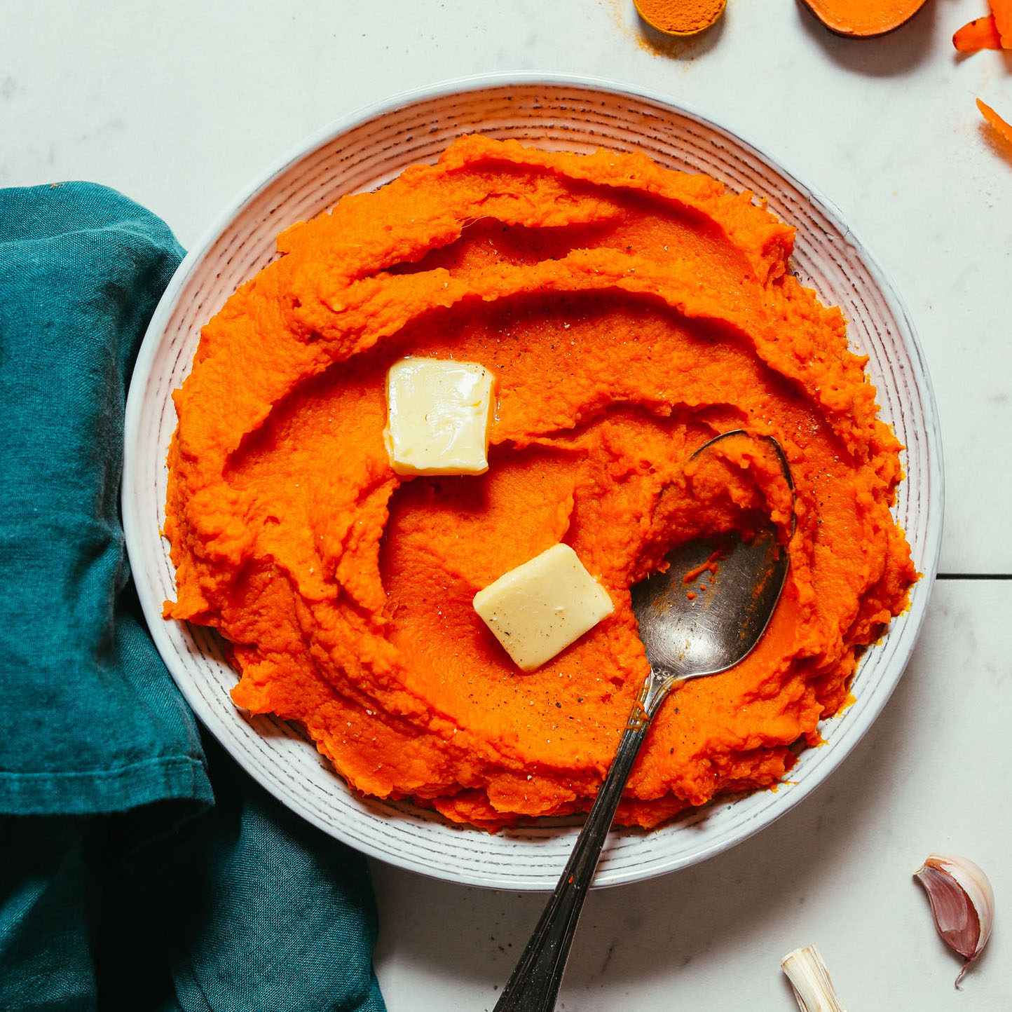Bowl of Fluffy Mashed Sweet Potatoes and Carrots with slices of vegan butter
