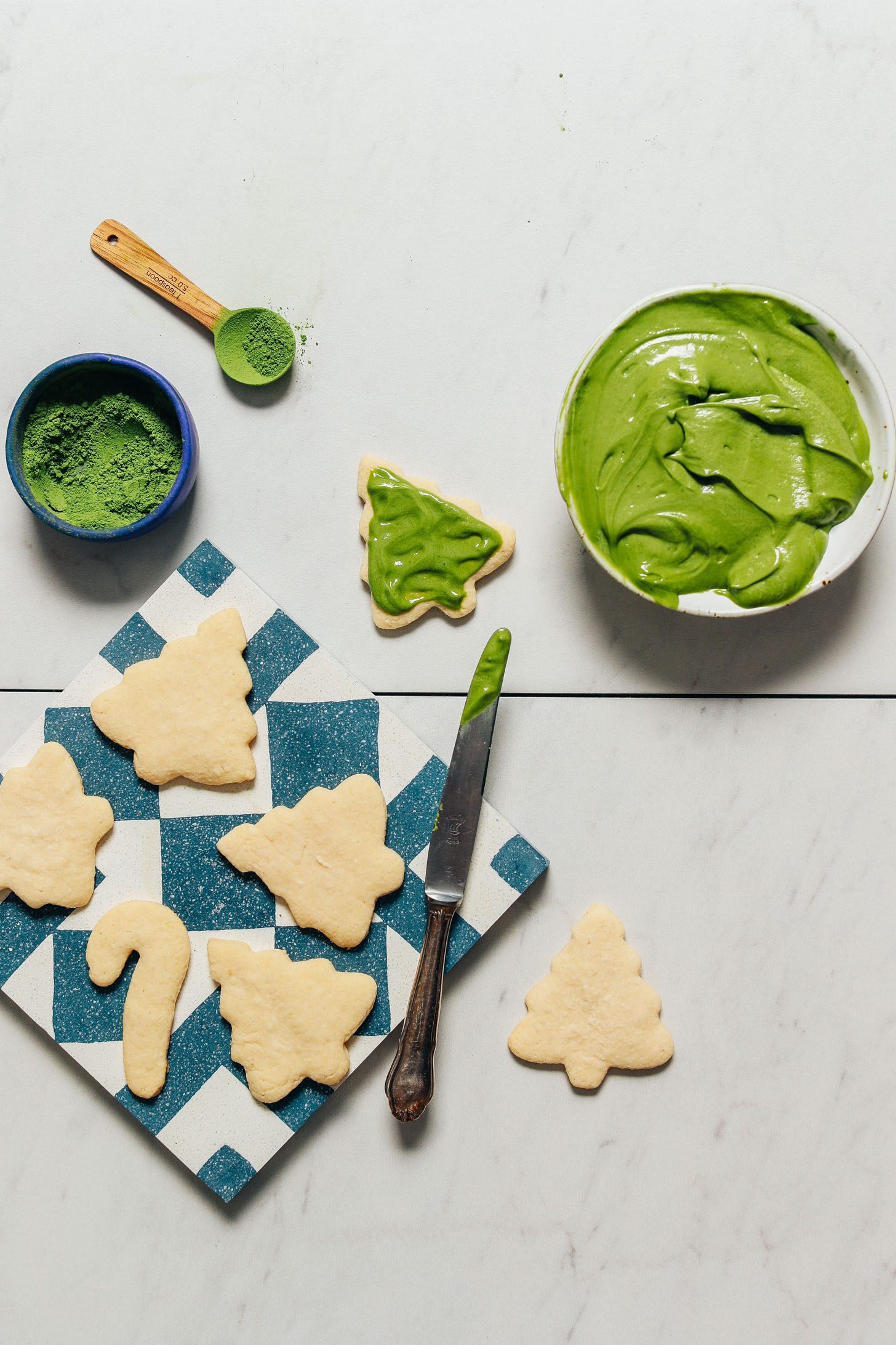Bowl of matcha frosting beside Grain-Free Sugar Cookies for a natural Christmas cookie frosting idea