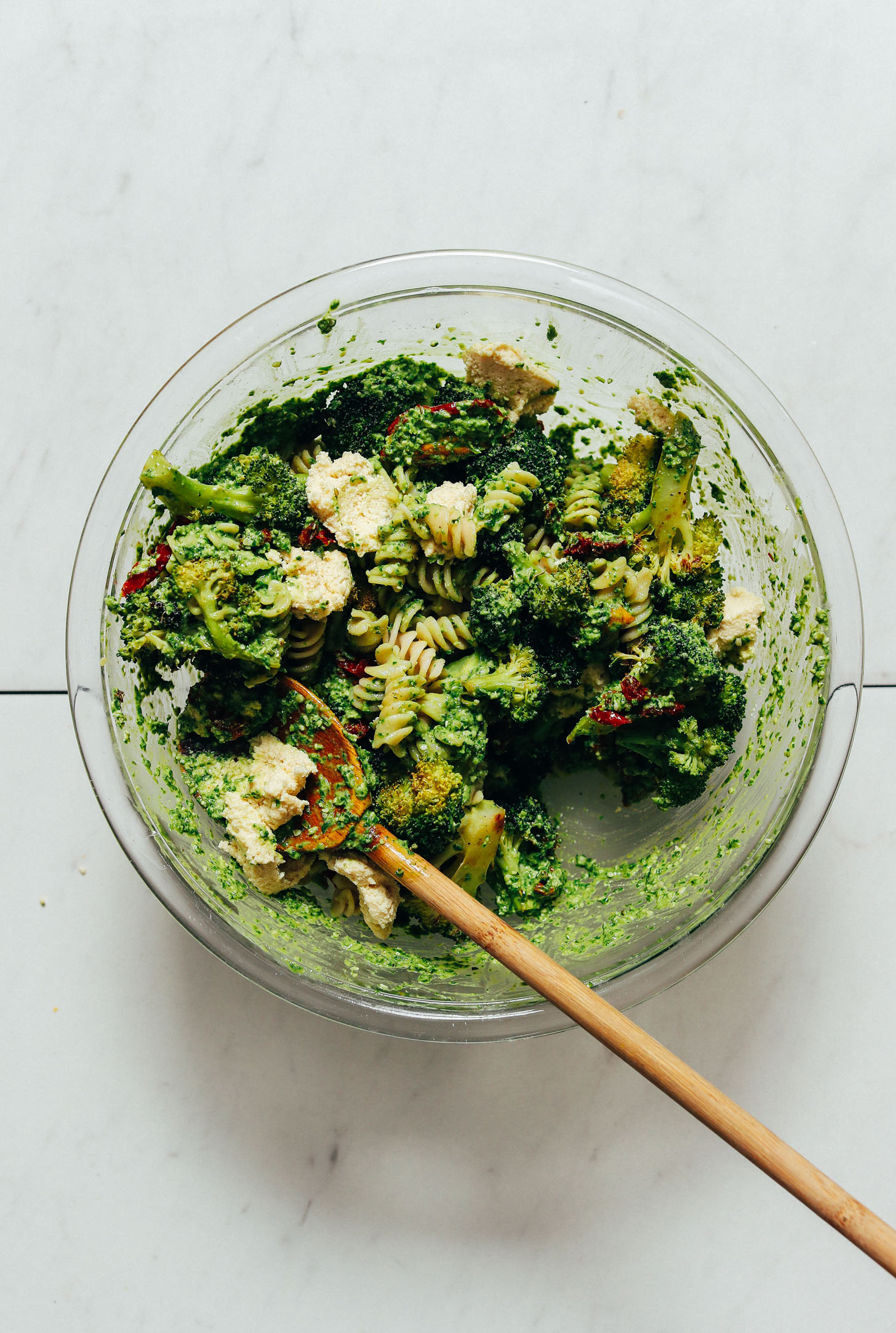 Bowl of Pesto Broccoli Pasta Salad with Sun-Dried Tomatoes and Vegan Macadamia Nut Cheese