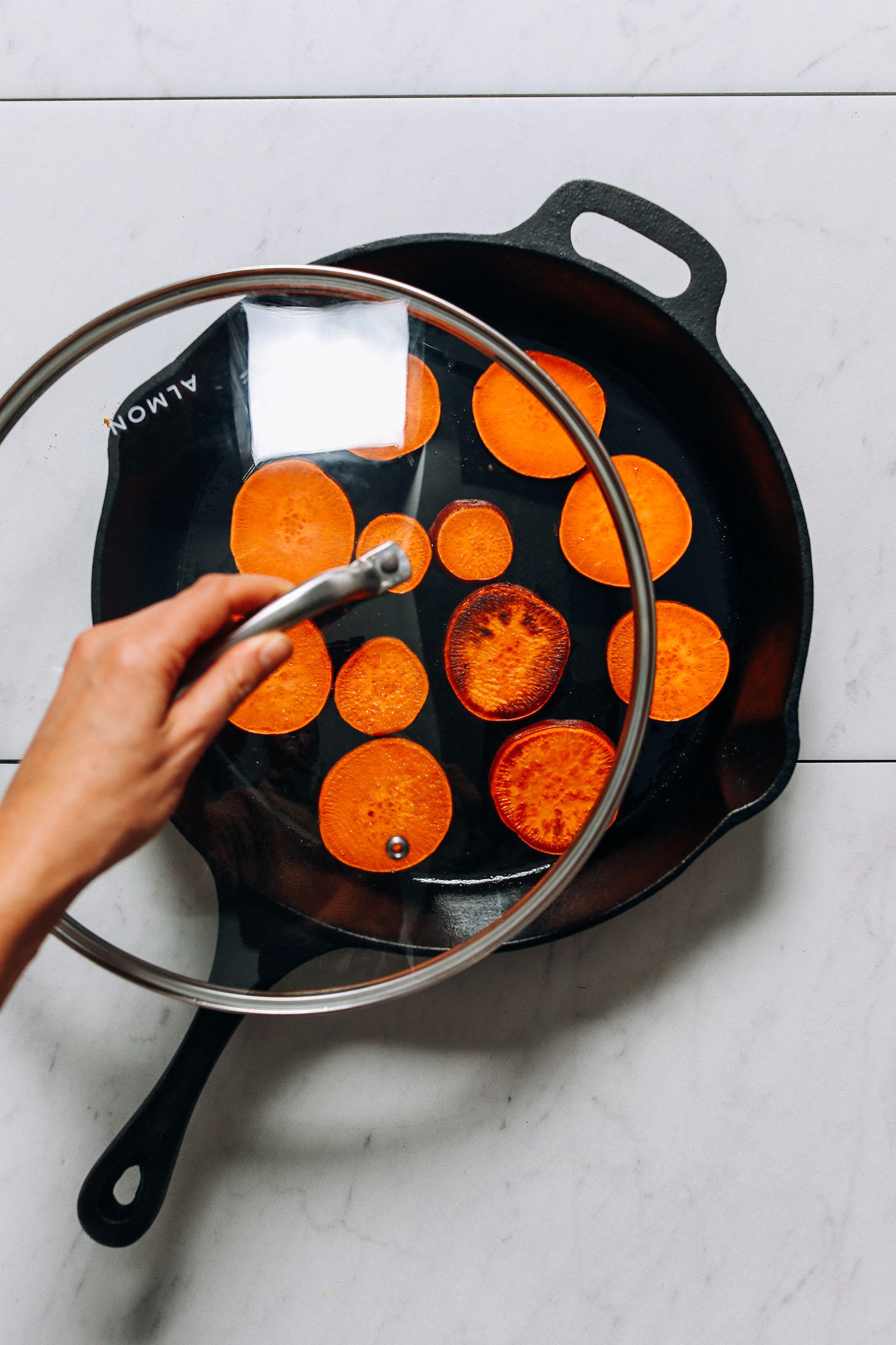 Covering a pan of sweet potatoes to help them cook through fully