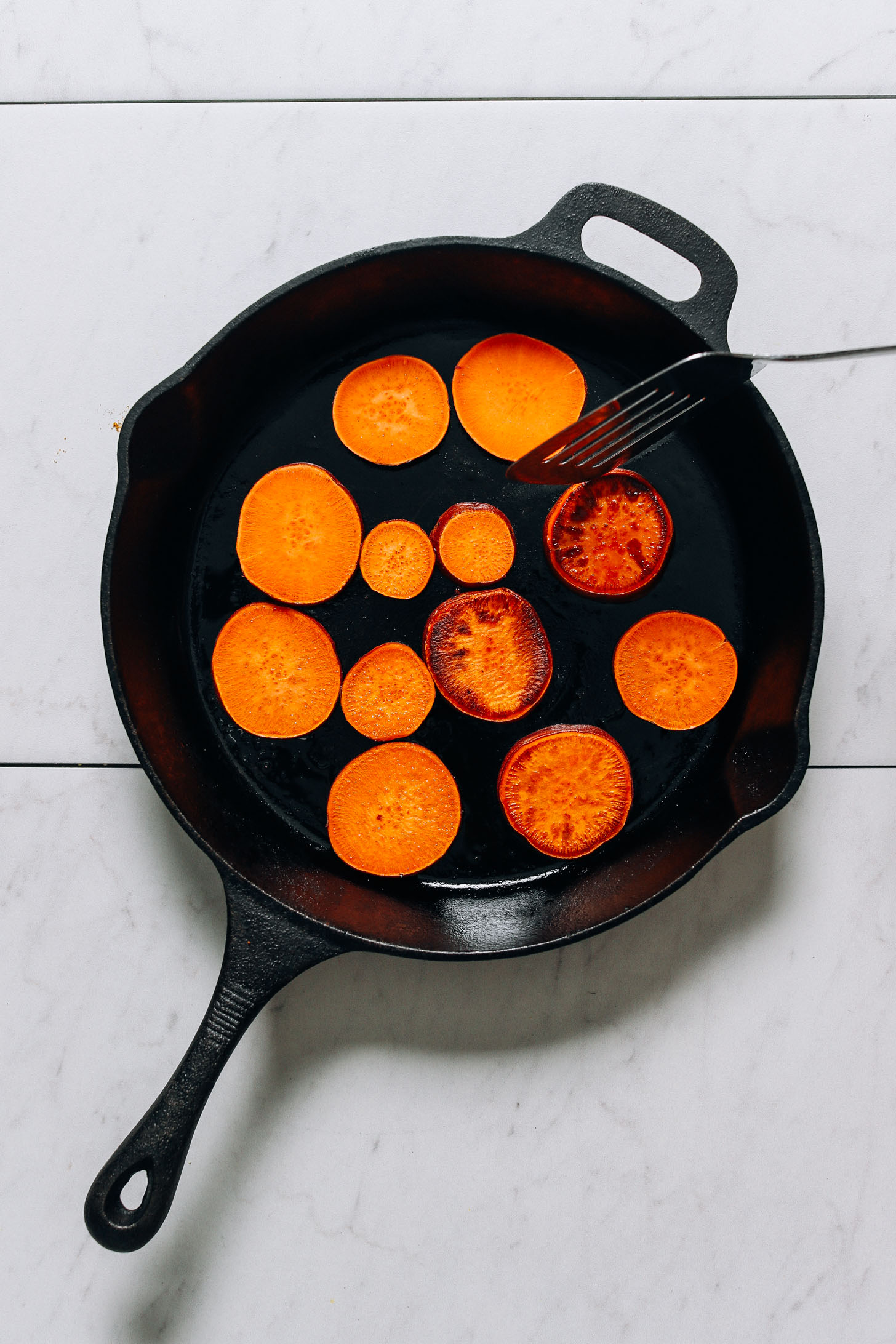 Cooking sweet potato slices in a cast iron skillet