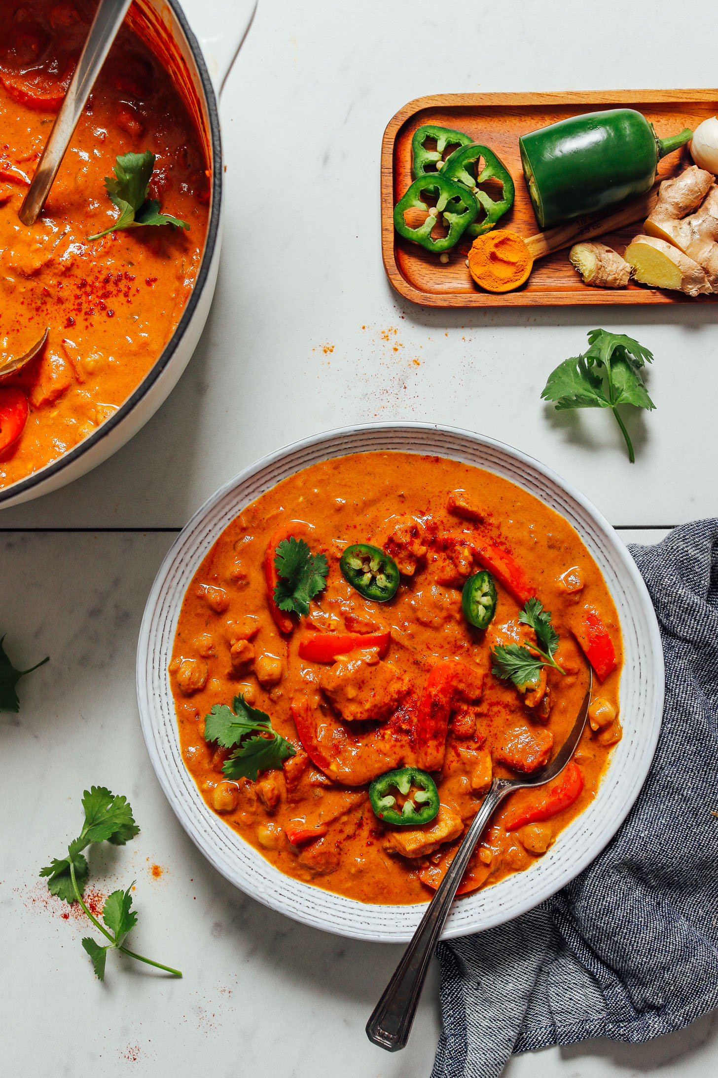 Pot and bowl of easy homemade Tikka Masala topped with cilantro and jalapeno
