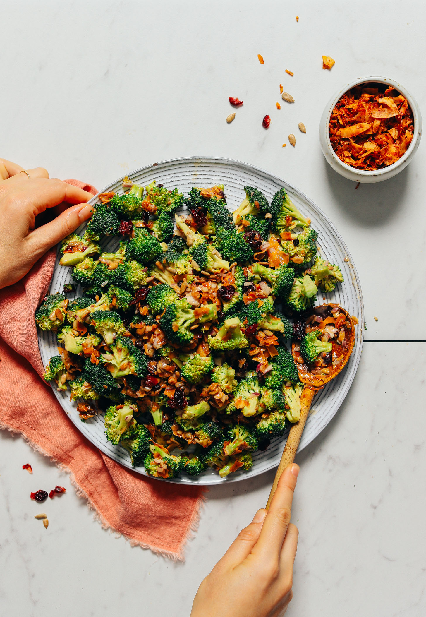 Plate filled with Creamy Vegan Broccoli Salad made with coconut bacon, cranberries, and a cashew butter dressing