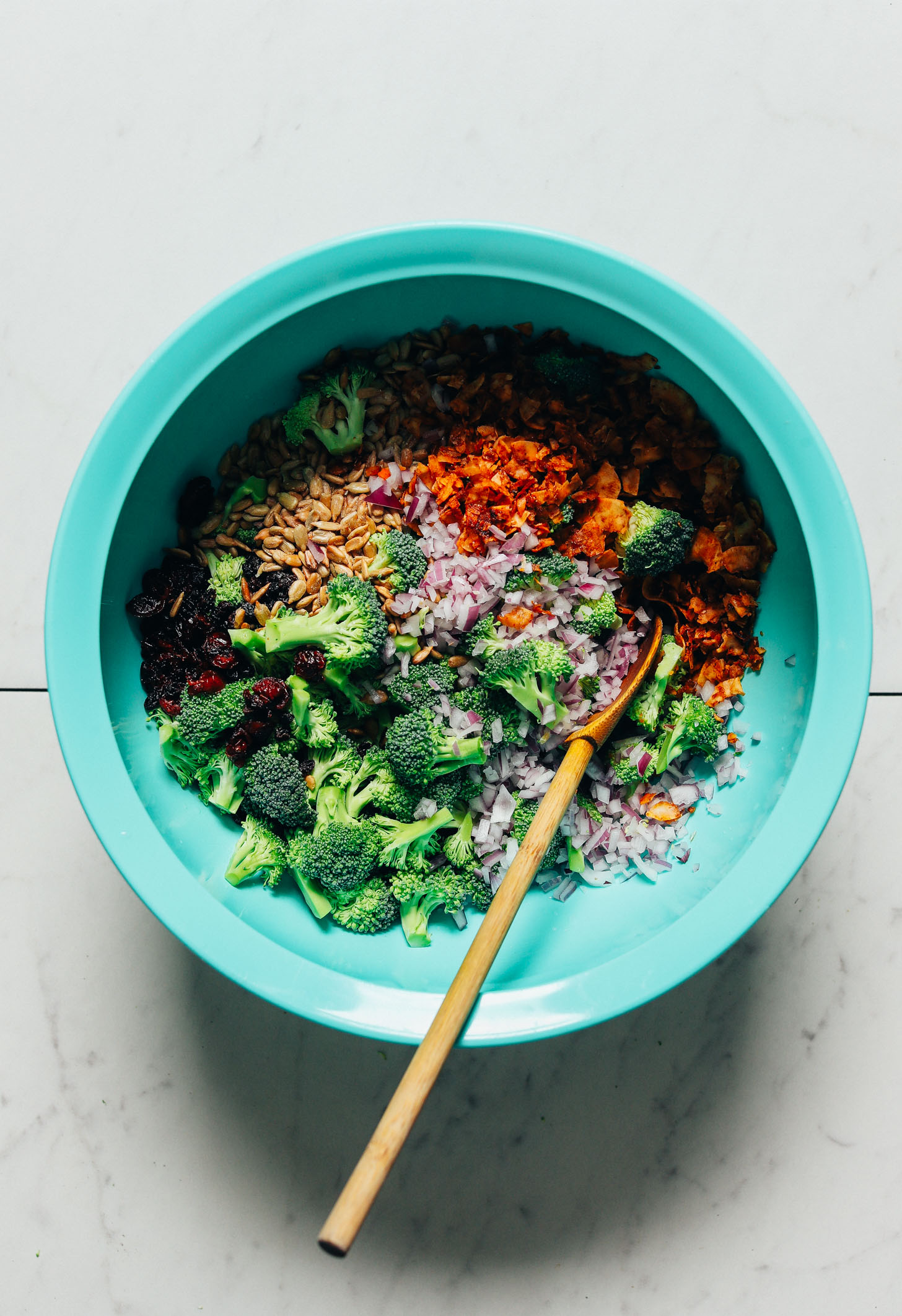 Mixing bowl filled with ingredients for making our Creamy Vegan Broccoli Salad recipe