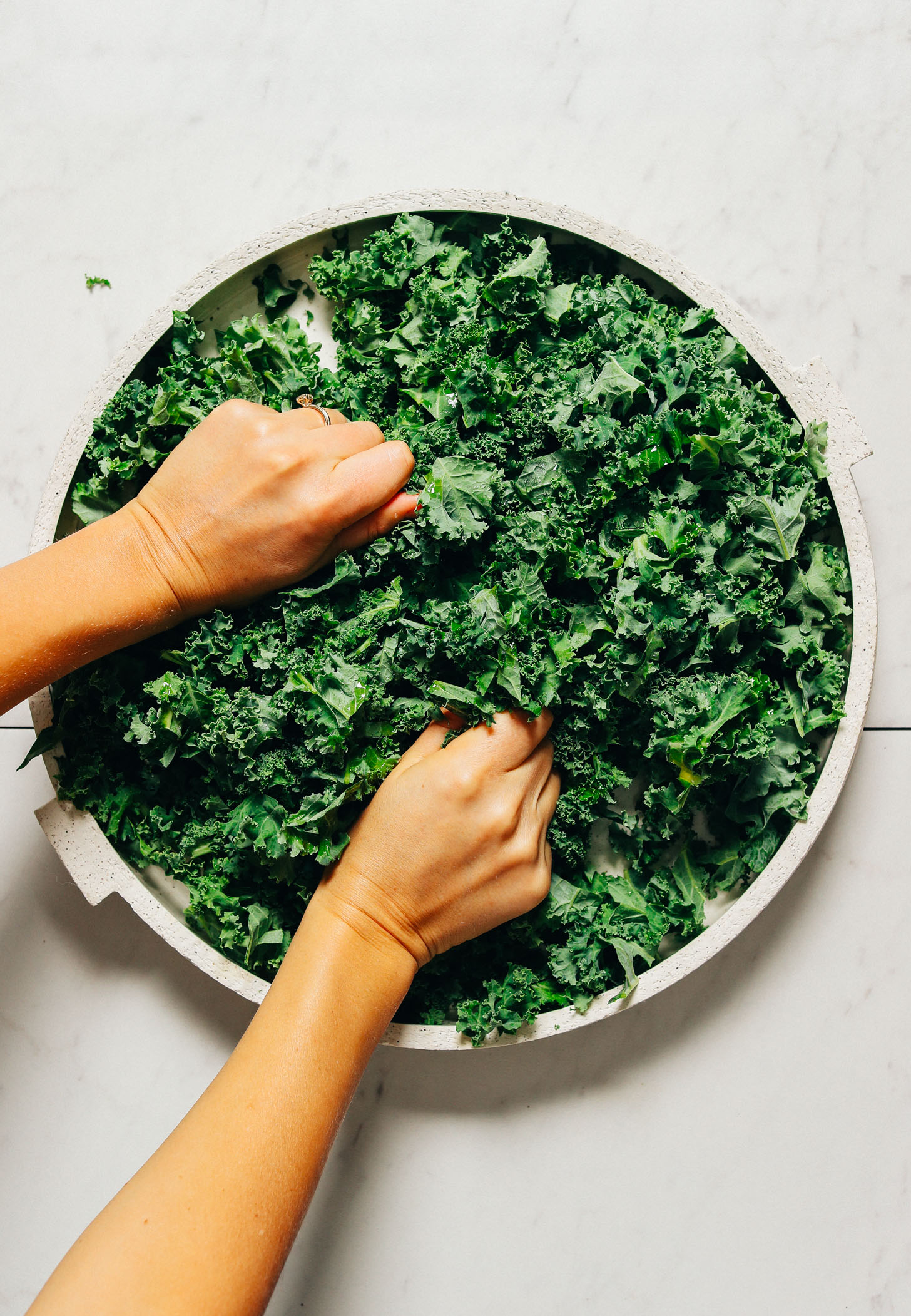 Massaging kale on a large platter