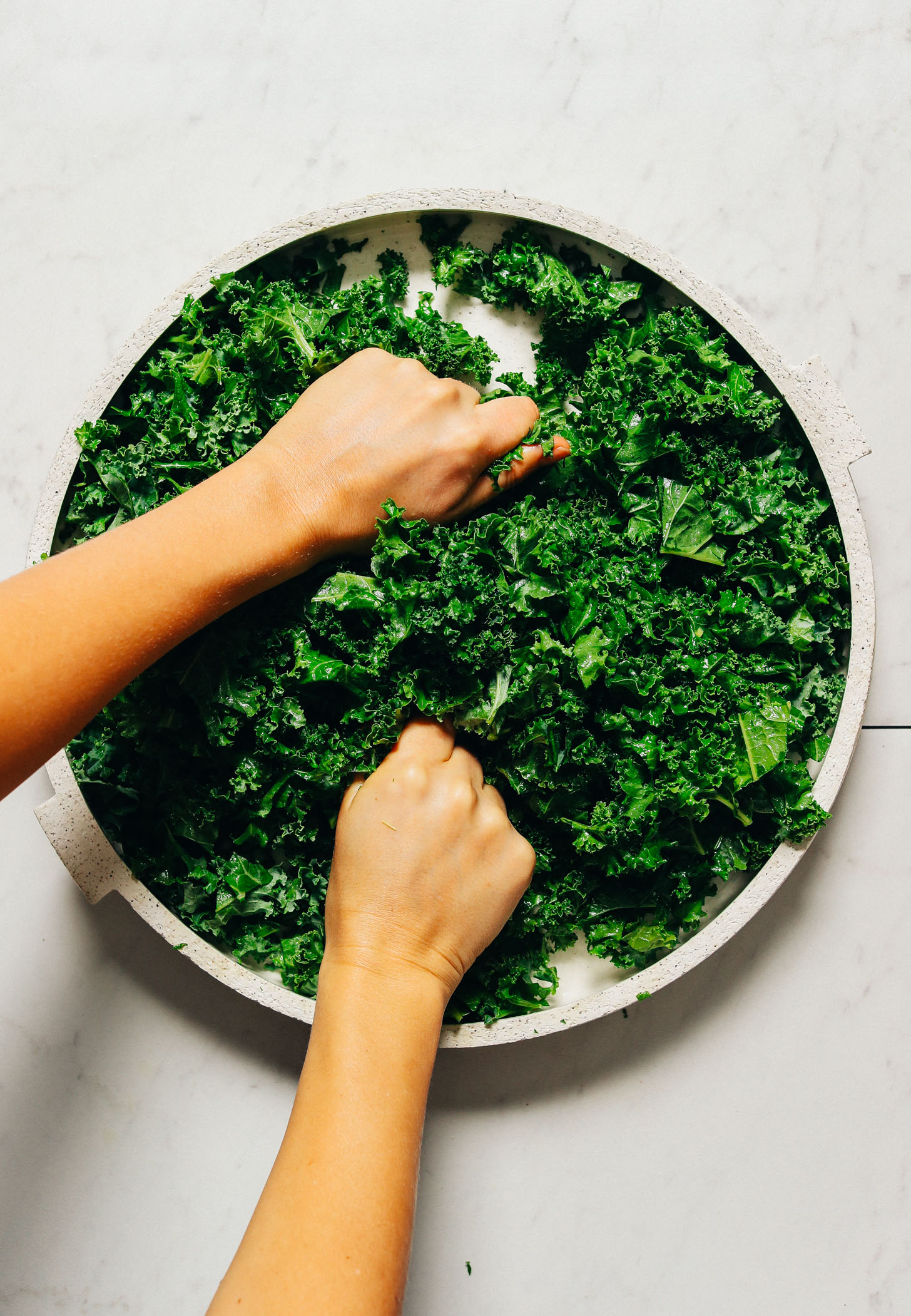 Massaging kale on a large platter