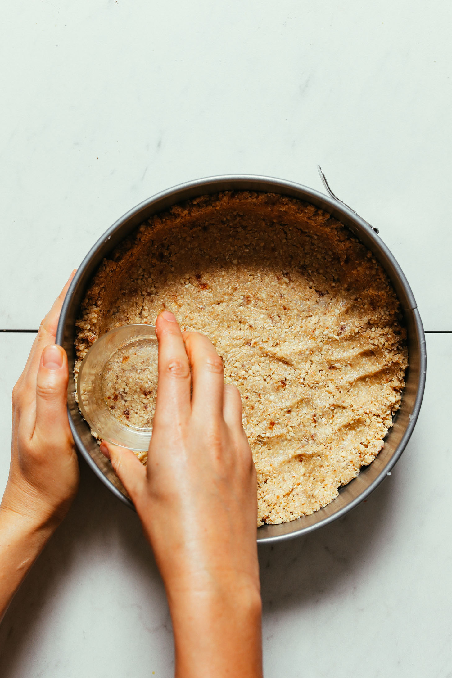 Using a glass to press the crust for our Cashew-Oat Pumpkin Pie Crust