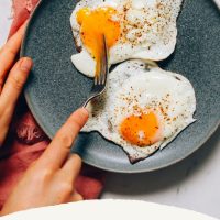 Plate with two perfectly cooked sunny-side up eggs for our tutorial on How to Cook Eggs