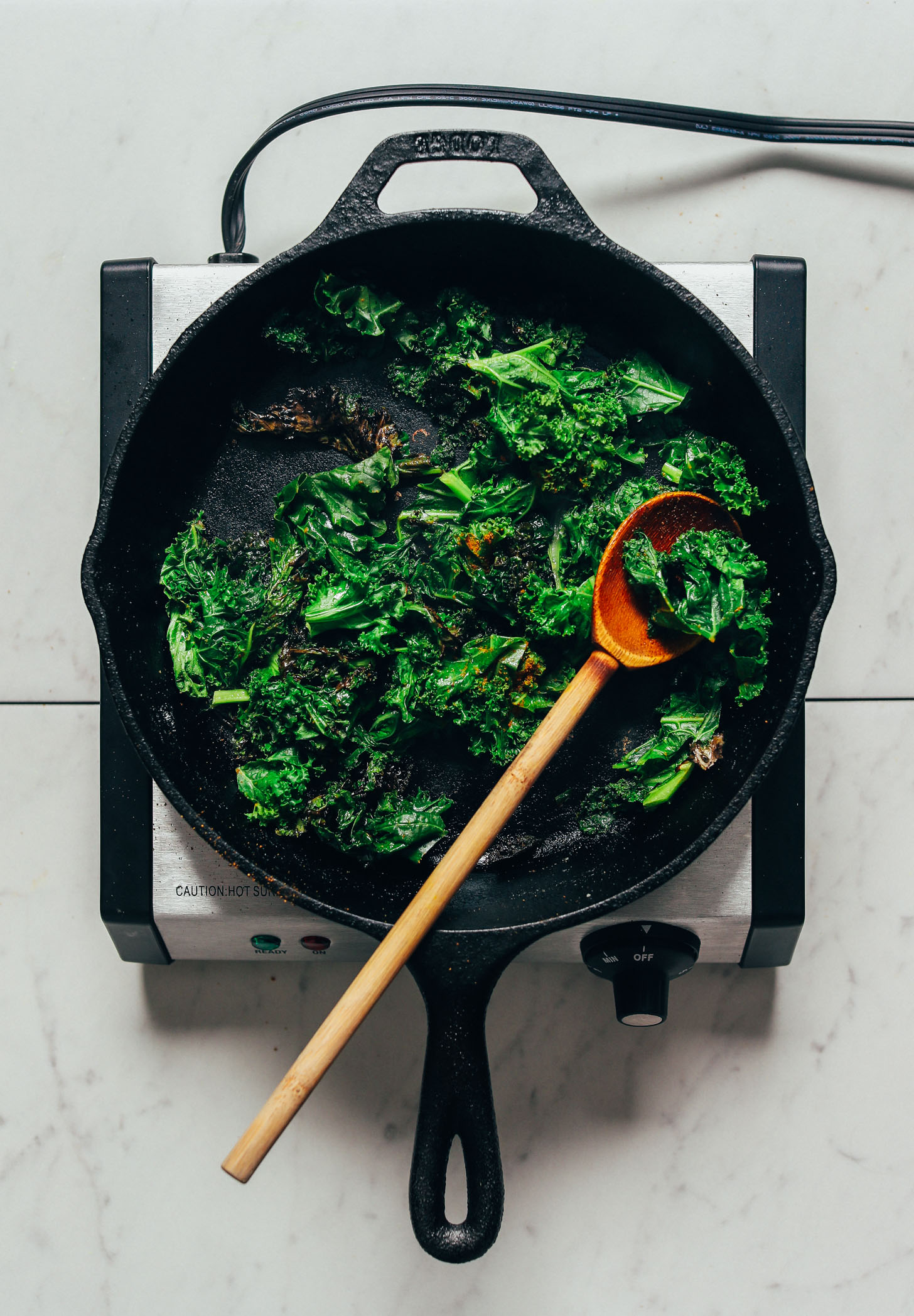 Sautรฉing kale in a cast iron skillet