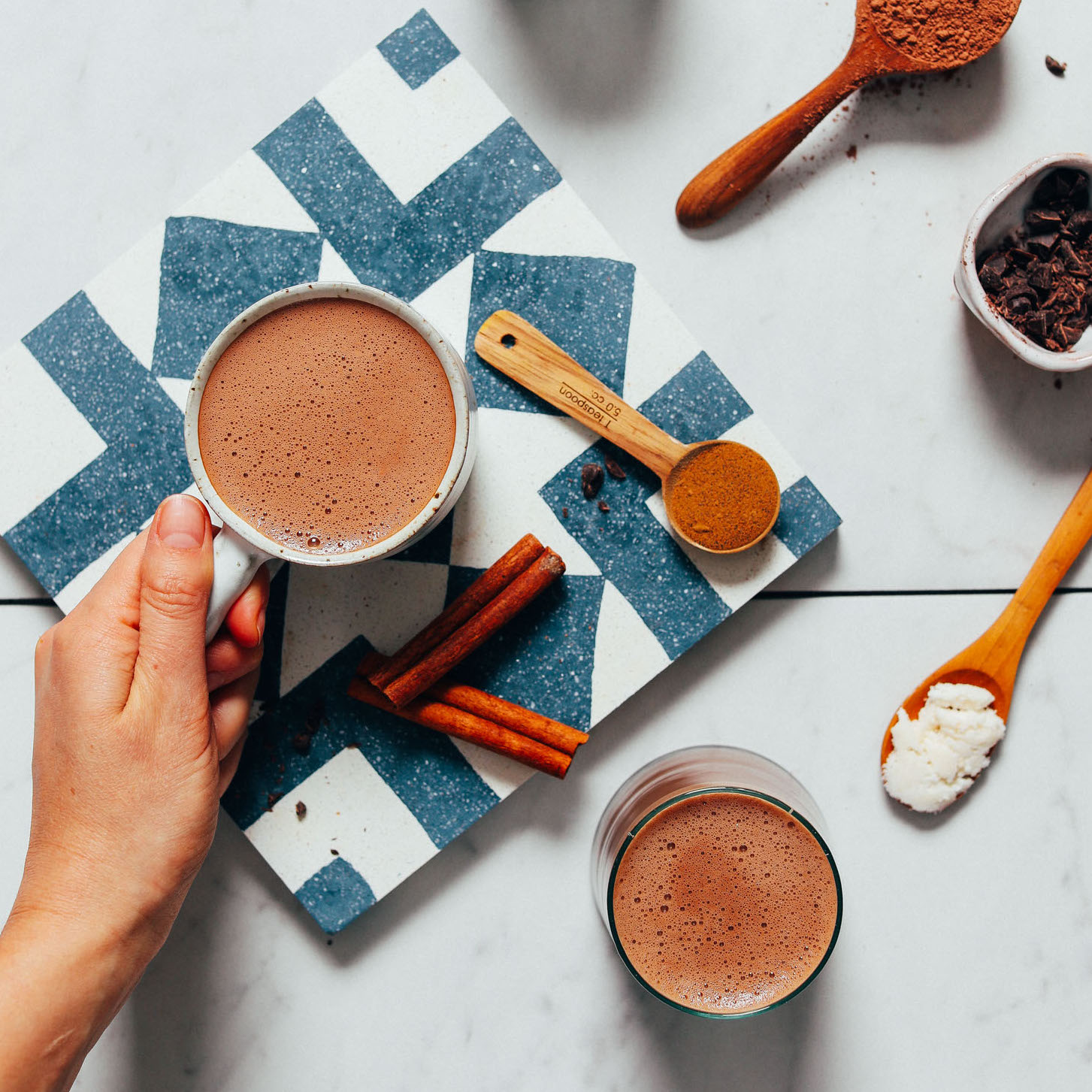 Holding the handle of a mug of vegan Hot Chocolate made with adaptogens