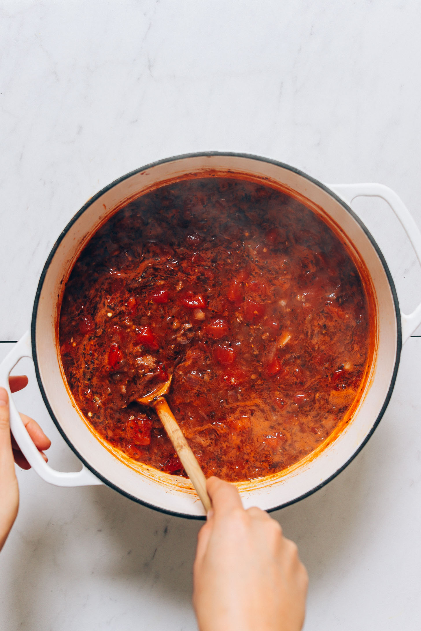 Using a wooden spoon to stir a pot of our Tuscan Beef and Lentil Soup