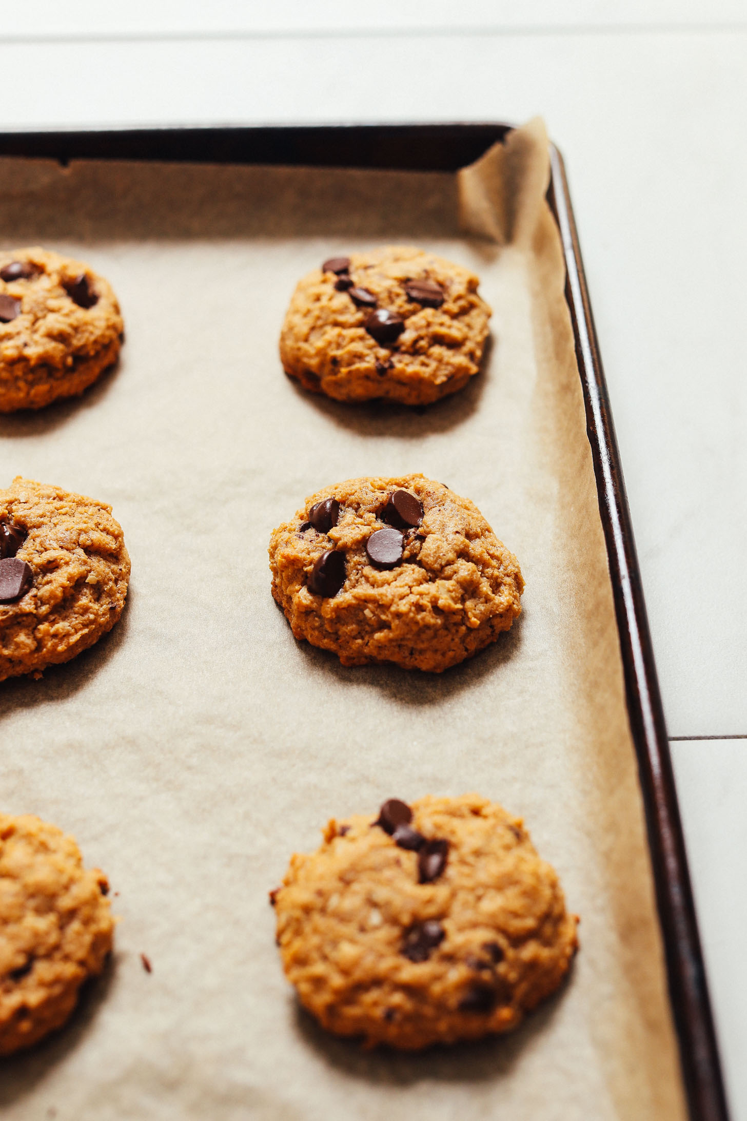 Peanut butter cookies cooling on a parchment lined baking sheet
