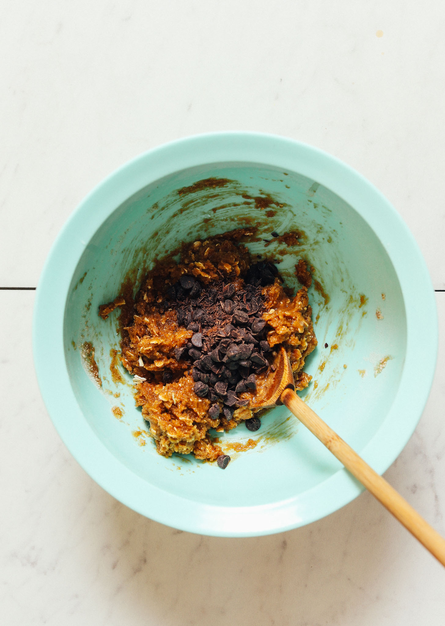 Chocolate chips in a bowl of gluten-free Peanut Butter Cookie batter