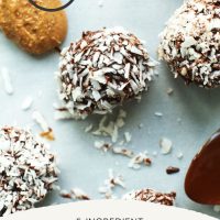 Almond Butter Dark Chocolate Snowballs on a parchment-lined baking sheet
