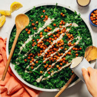 Pouring dressing over a massaged kale salad