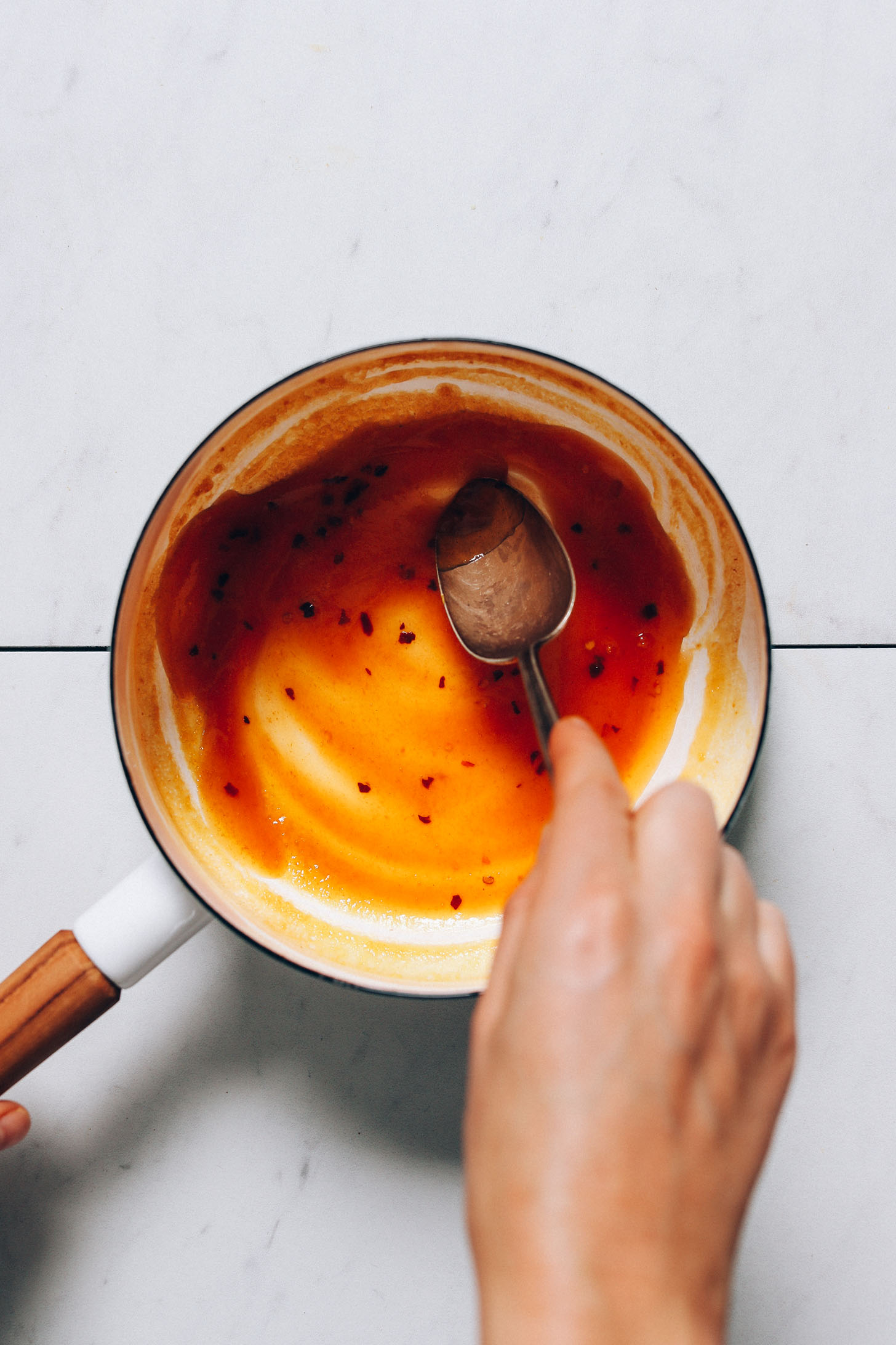 Stirring a pot of honey glaze for our Crispy Breaded Cauliflower recipe