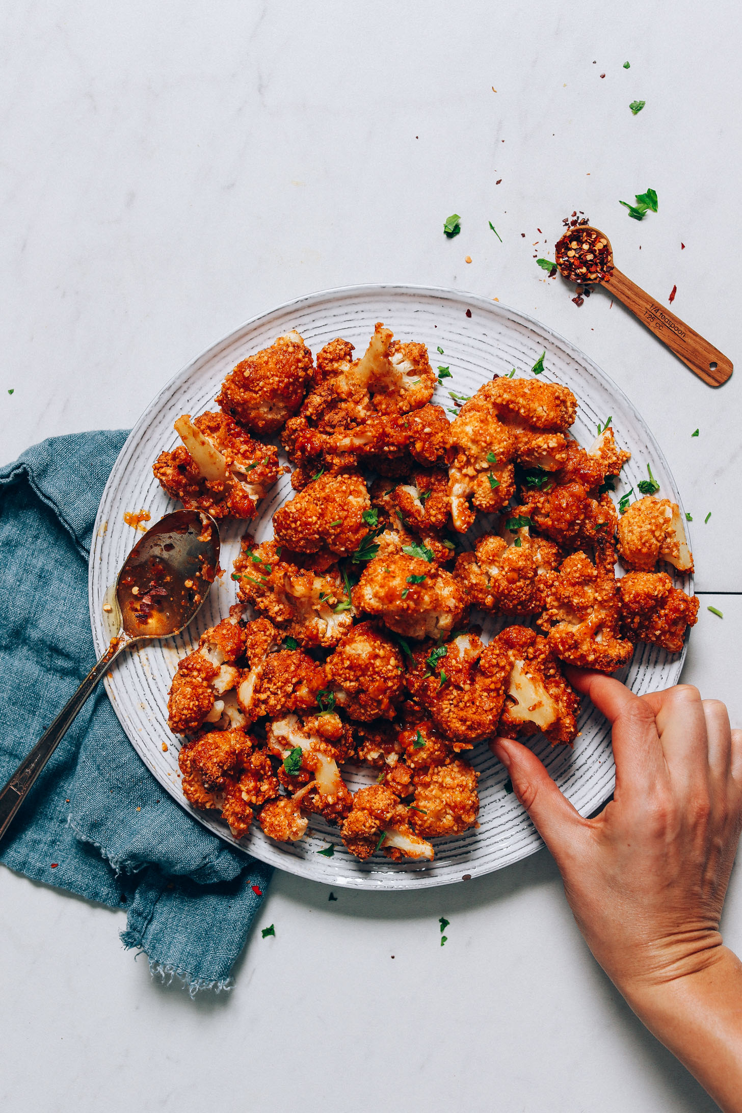 Picking up a Crispy Breaded Cauliflower Wing from a plate