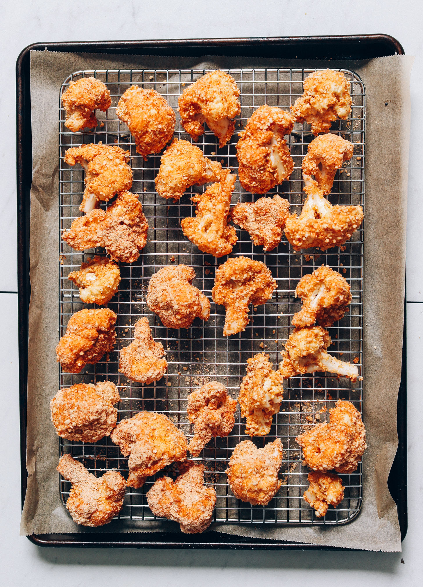 Gluten-Free Breaded Cauliflower Wings on a cooling rack atop a parchment-lined baking sheet