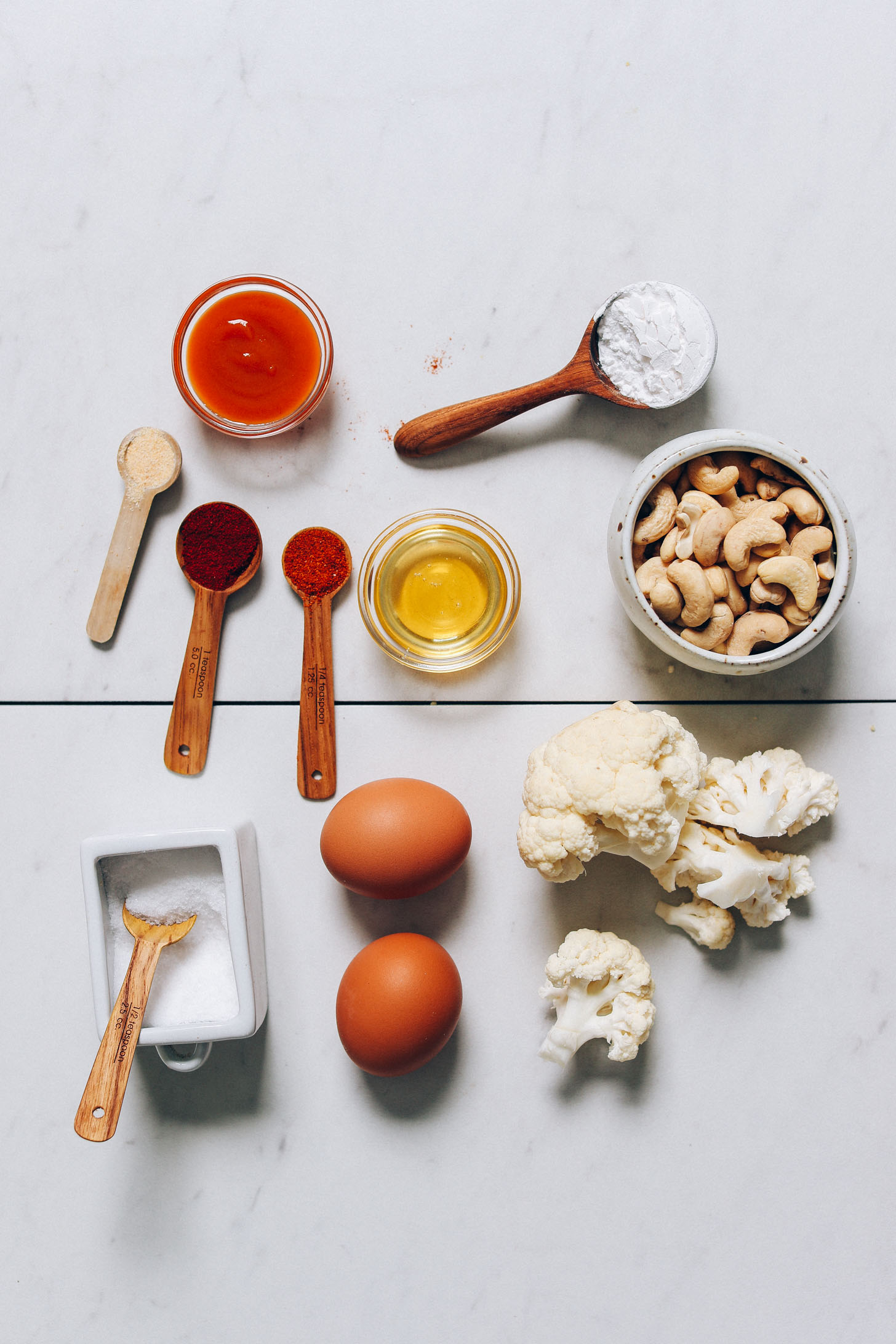 Cauliflower, cashews, eggs, honey, hot sauce, and other ingredients for making our Crispy Breaded Cauliflower recipe