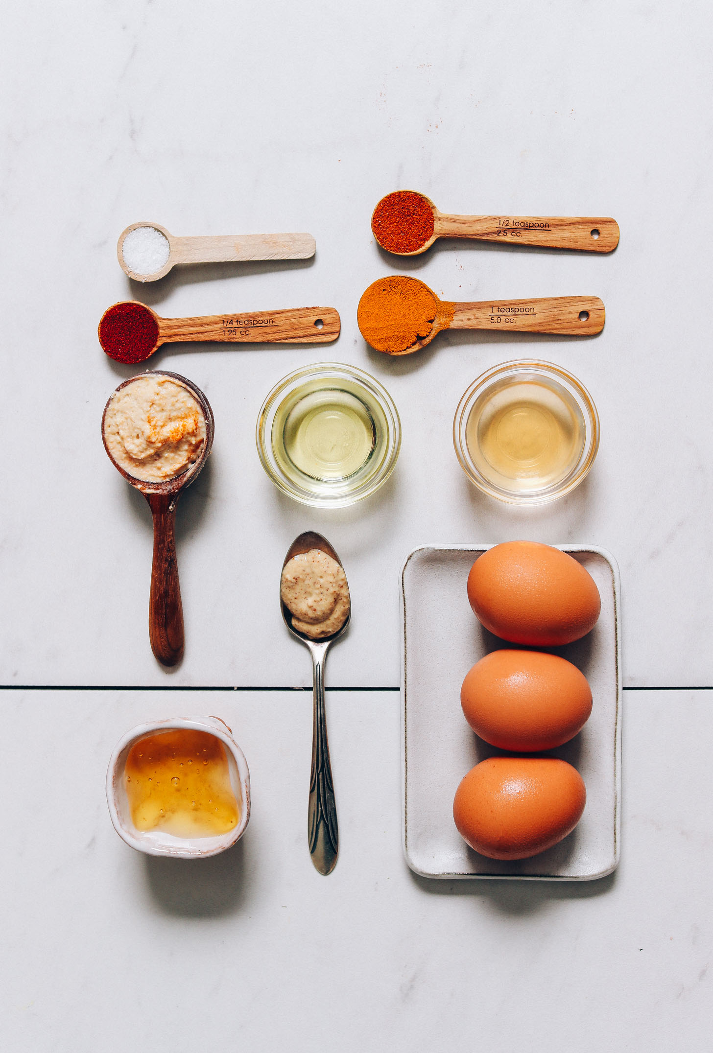 Hard boiled eggs, hummus, raw honey, and other ingredients for making our Mayo-Free Deviled Eggs recipe