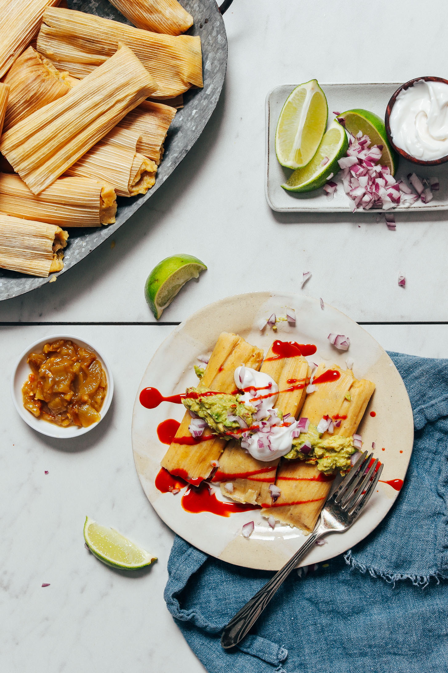 Tray and plate of tamales with toppings