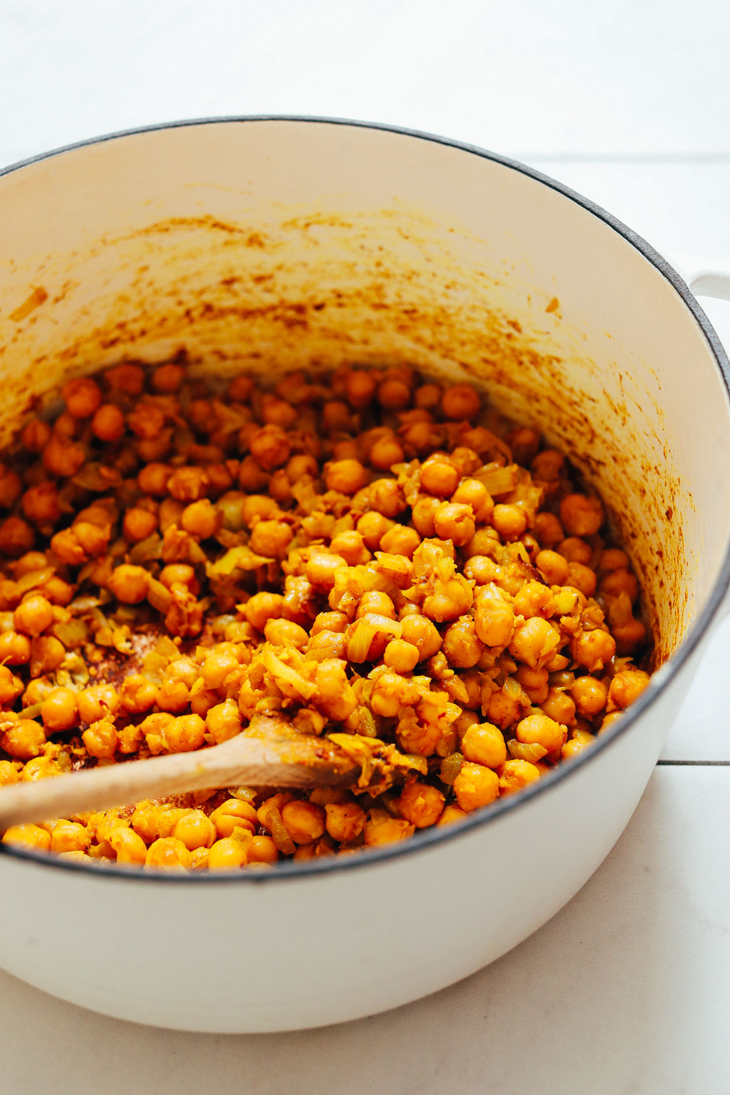 Wooden spoon resting in a pot of Curried Chickpea Soup