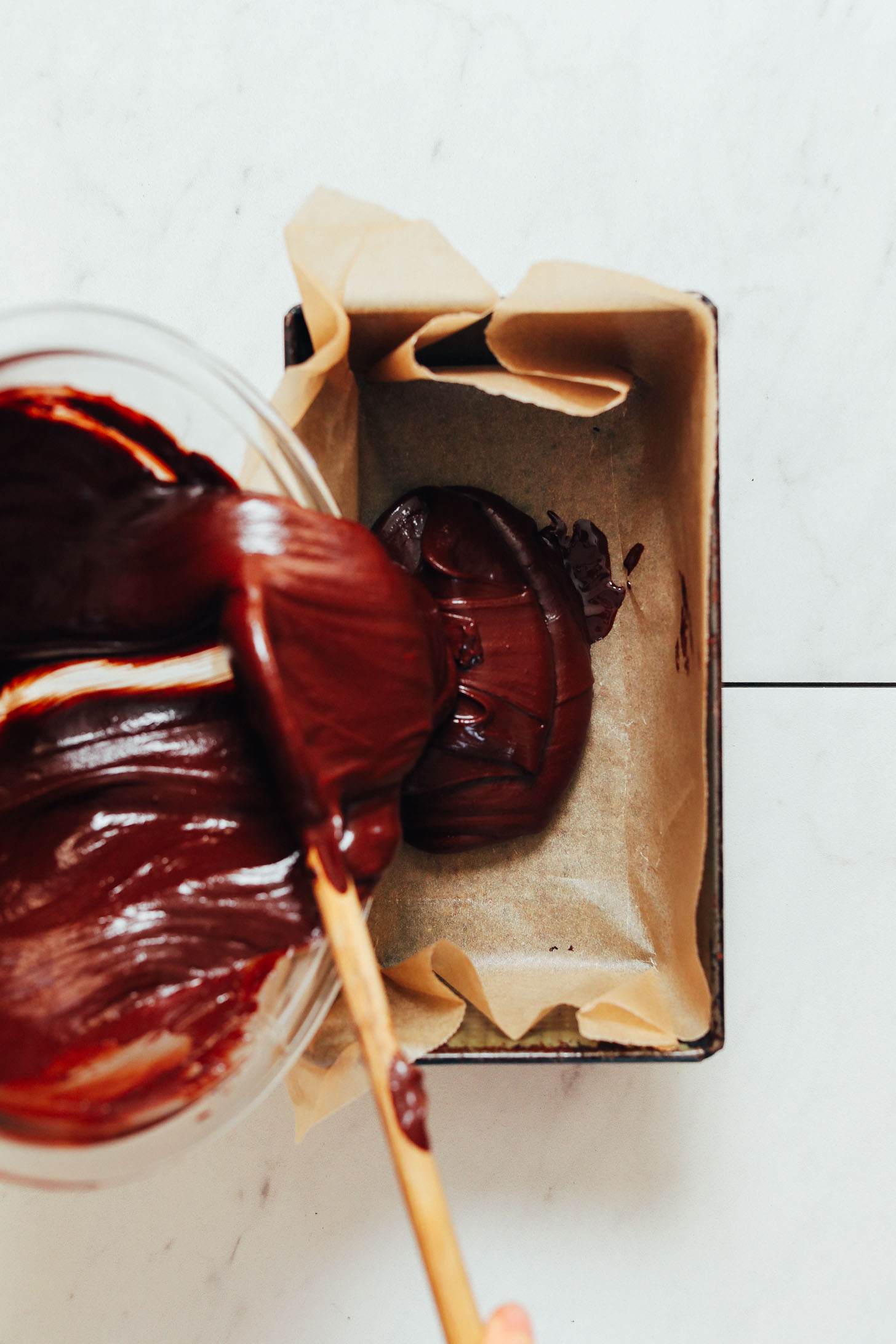 Pouring the batter for our Chocolate Fudge recipe into a parchment-lined pan
