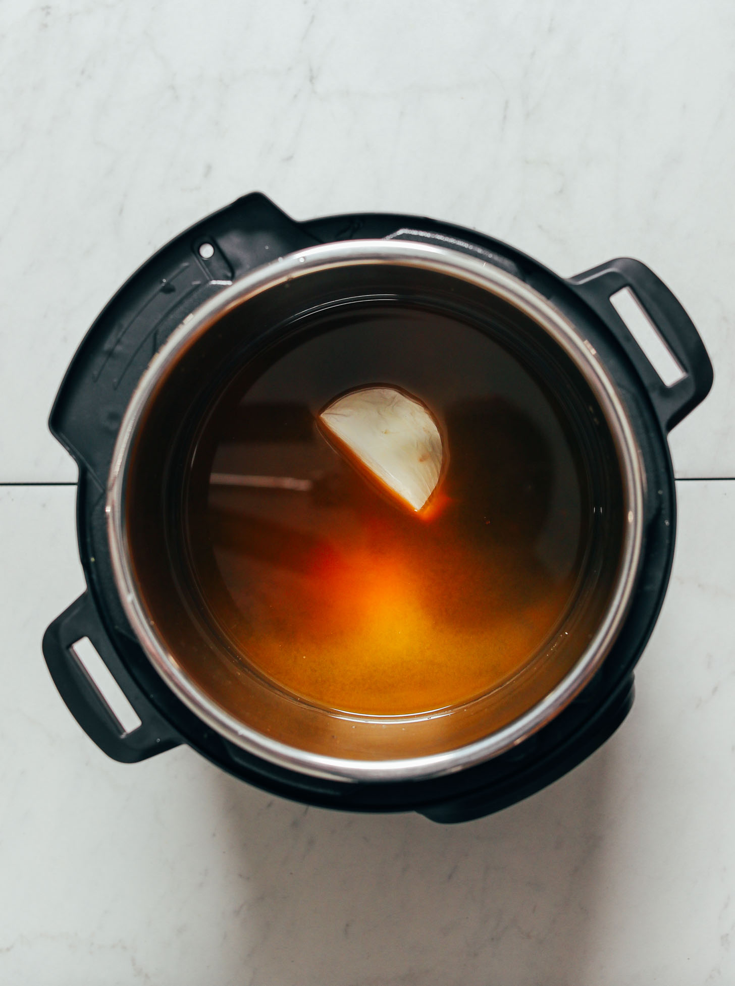 Broth, onion, and black beans in an Instant Pot