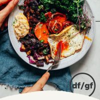 Using a fork to slice into a runny egg in our Simple But Good Breakfast Bowl recipe