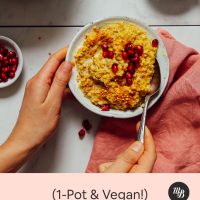 Using a spoon to scoop into a bowl of our Cozy Turmeric Porridge recipe