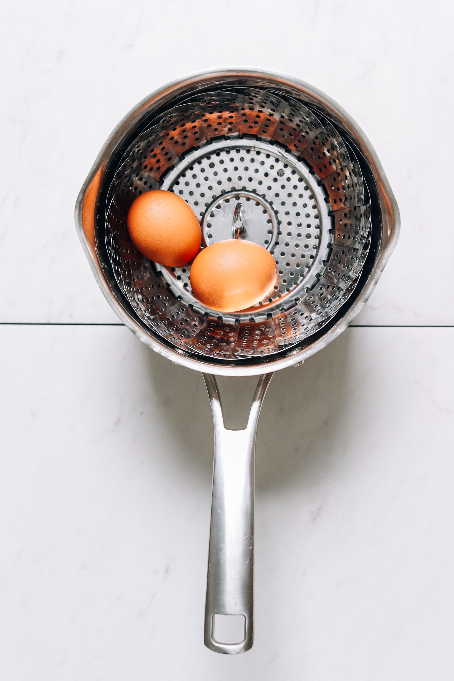 Eggs in a steamer basket to show how to steam hard boiled eggs