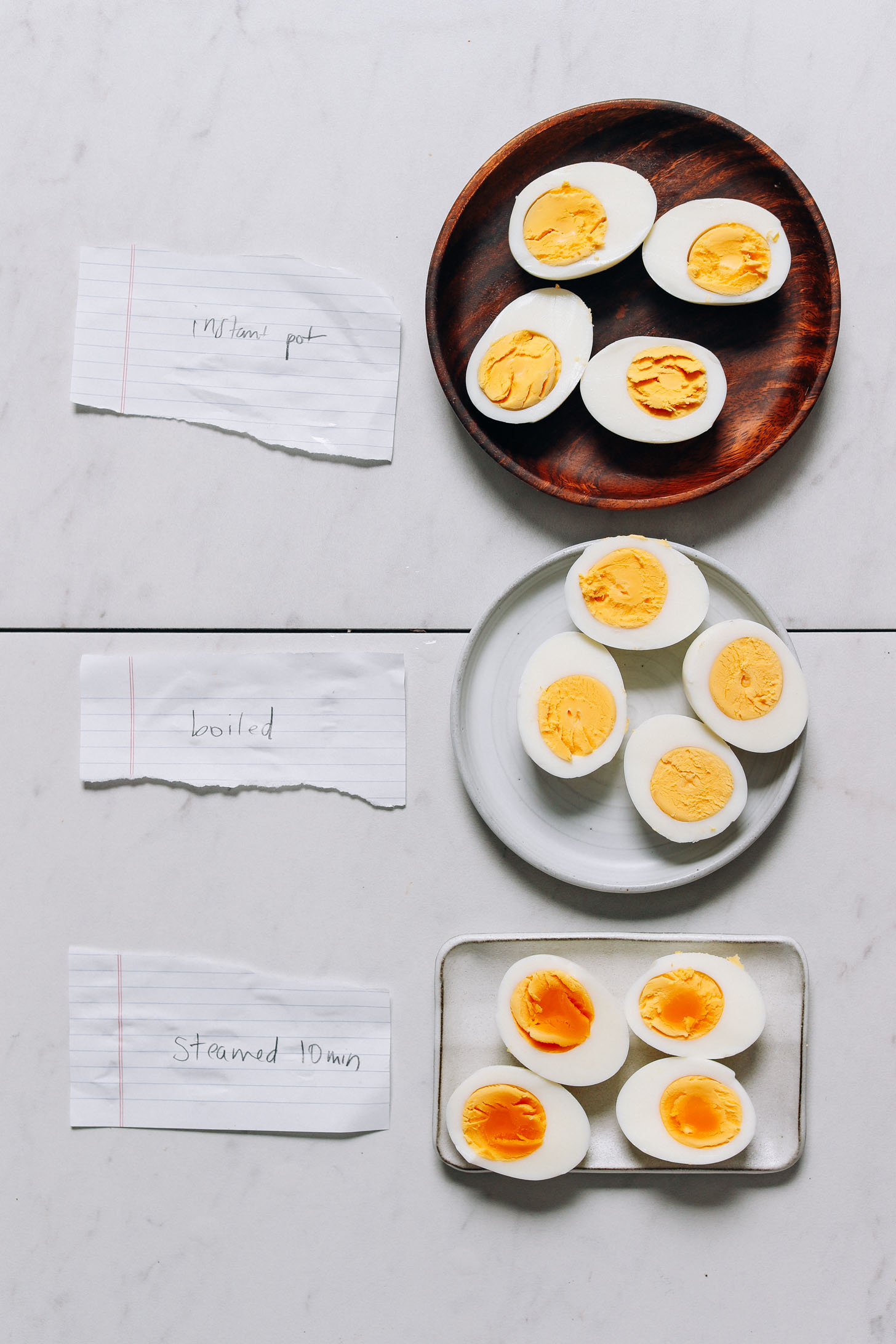 Plates with halved hard boiled eggs made in the Instant Pot, a saucepan, and a steamer basket