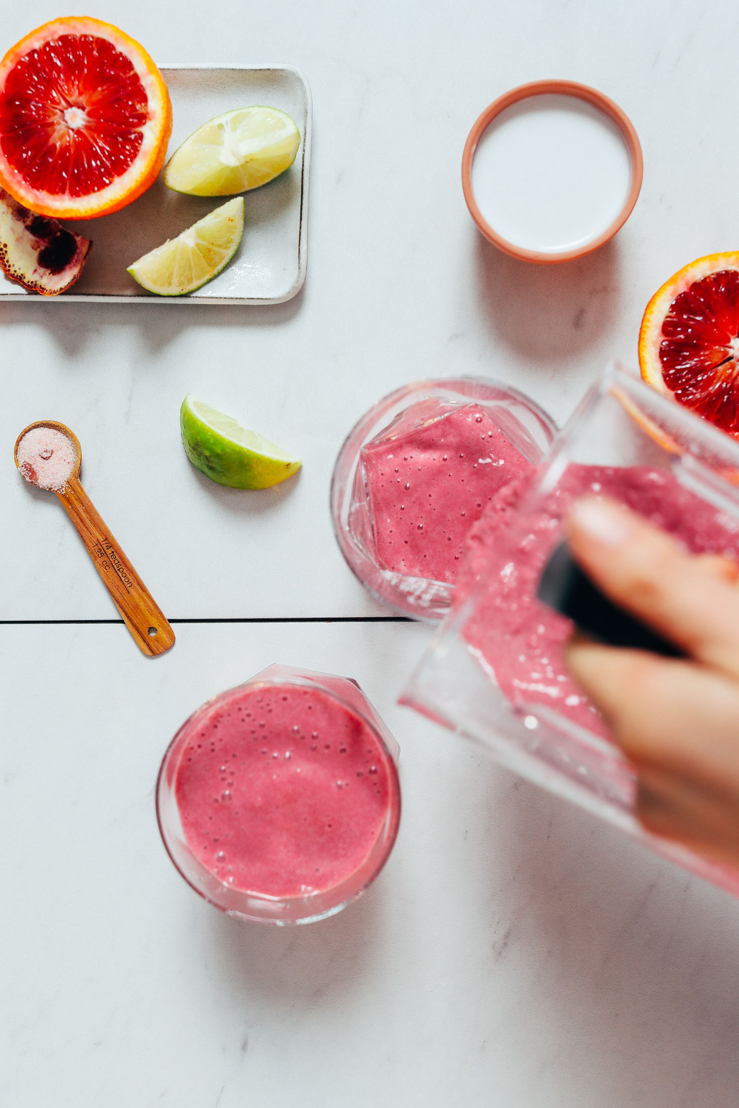 Pouring Orange Creamsicle Smoothies from a blender into glasses