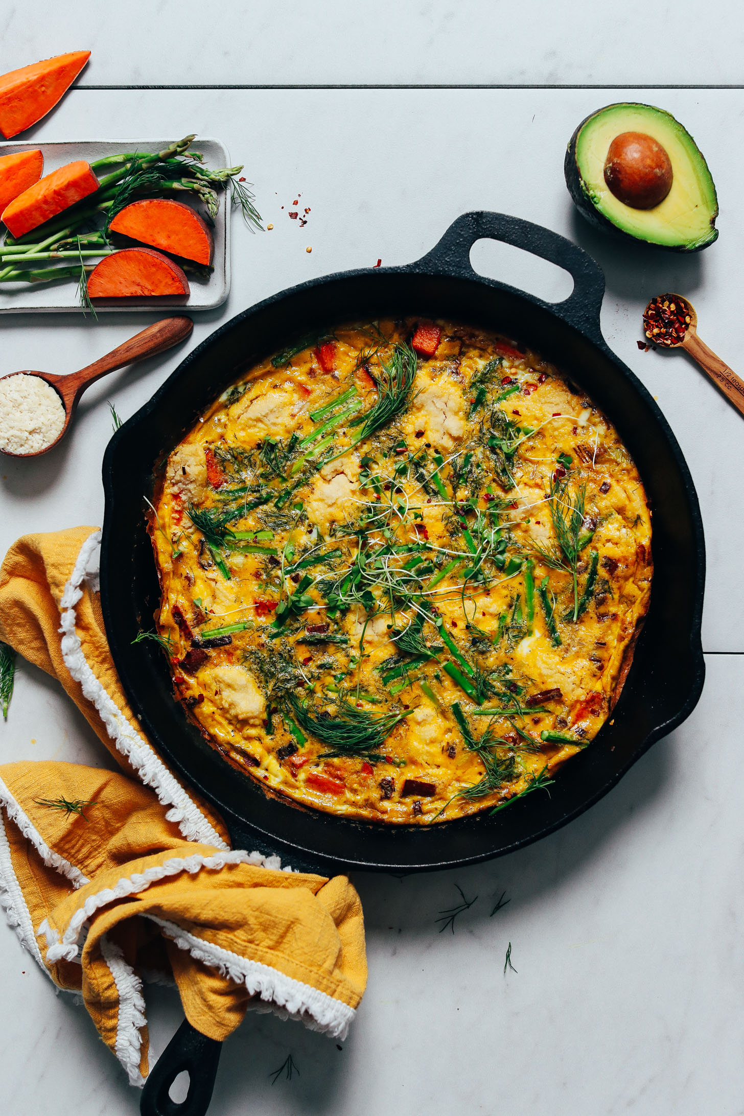 Cast iron skillet of our Spring Frittata topped with microgreens 