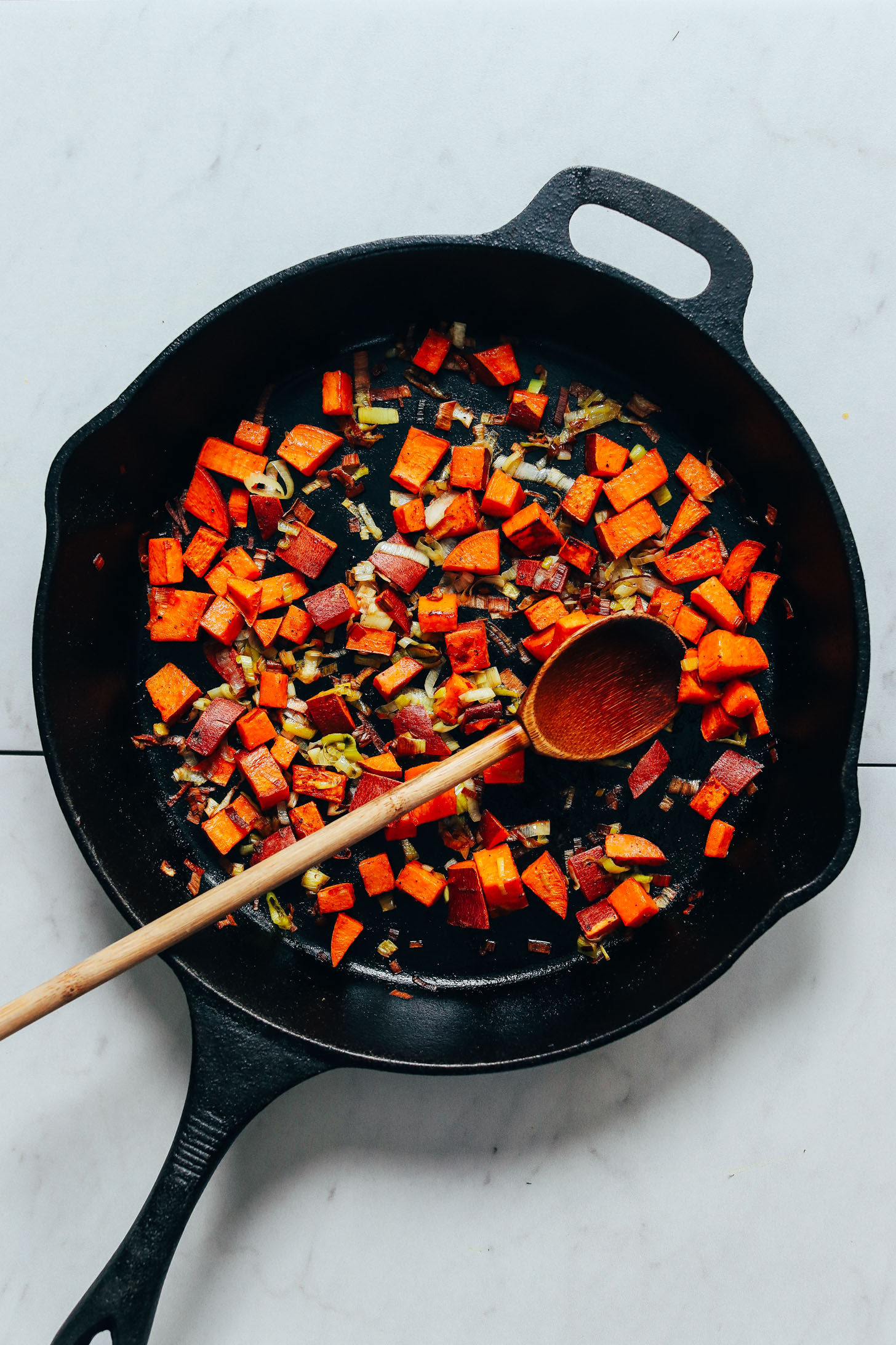 Sautéing leek and sweet potato in a skillet to make our Spring Frittata recipe