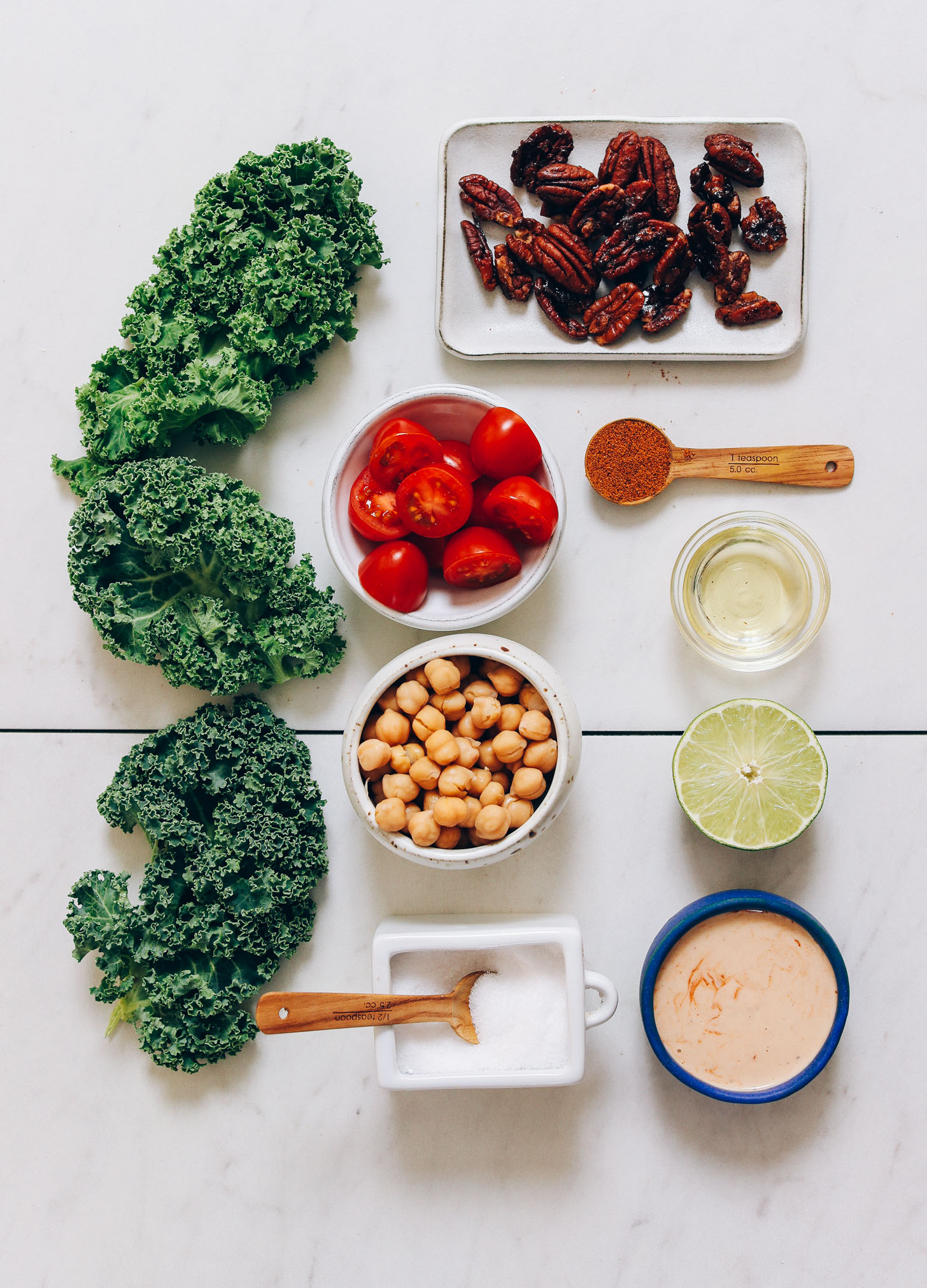 Kale, grape tomatoes, candied pecans, chickpeas, and other ingredients for making our Vegan Chopped Kale Salad with Adobo Dressing