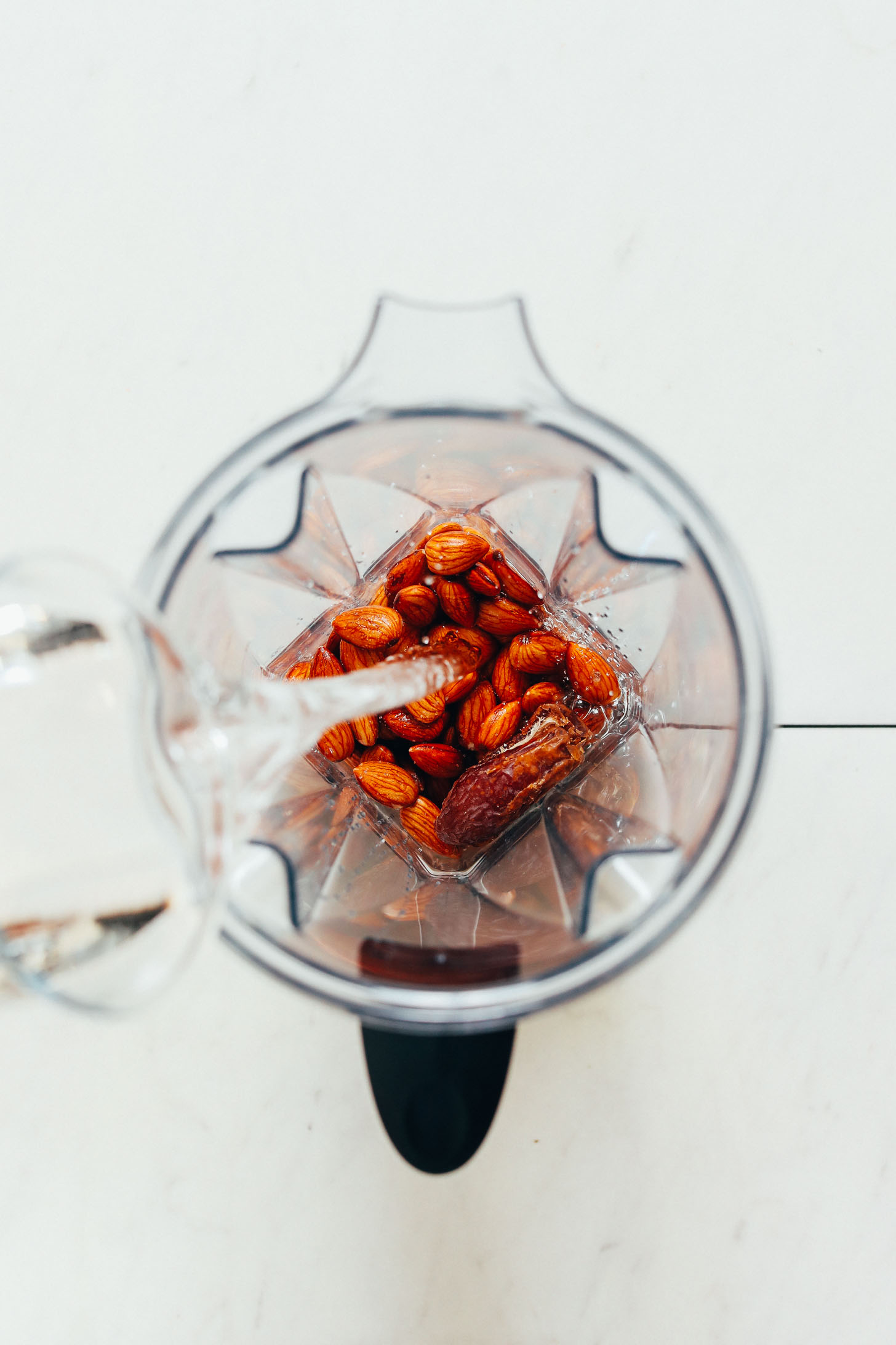 Adding water to a blender filled with almonds for our Homemade Coffee Creamer recipe