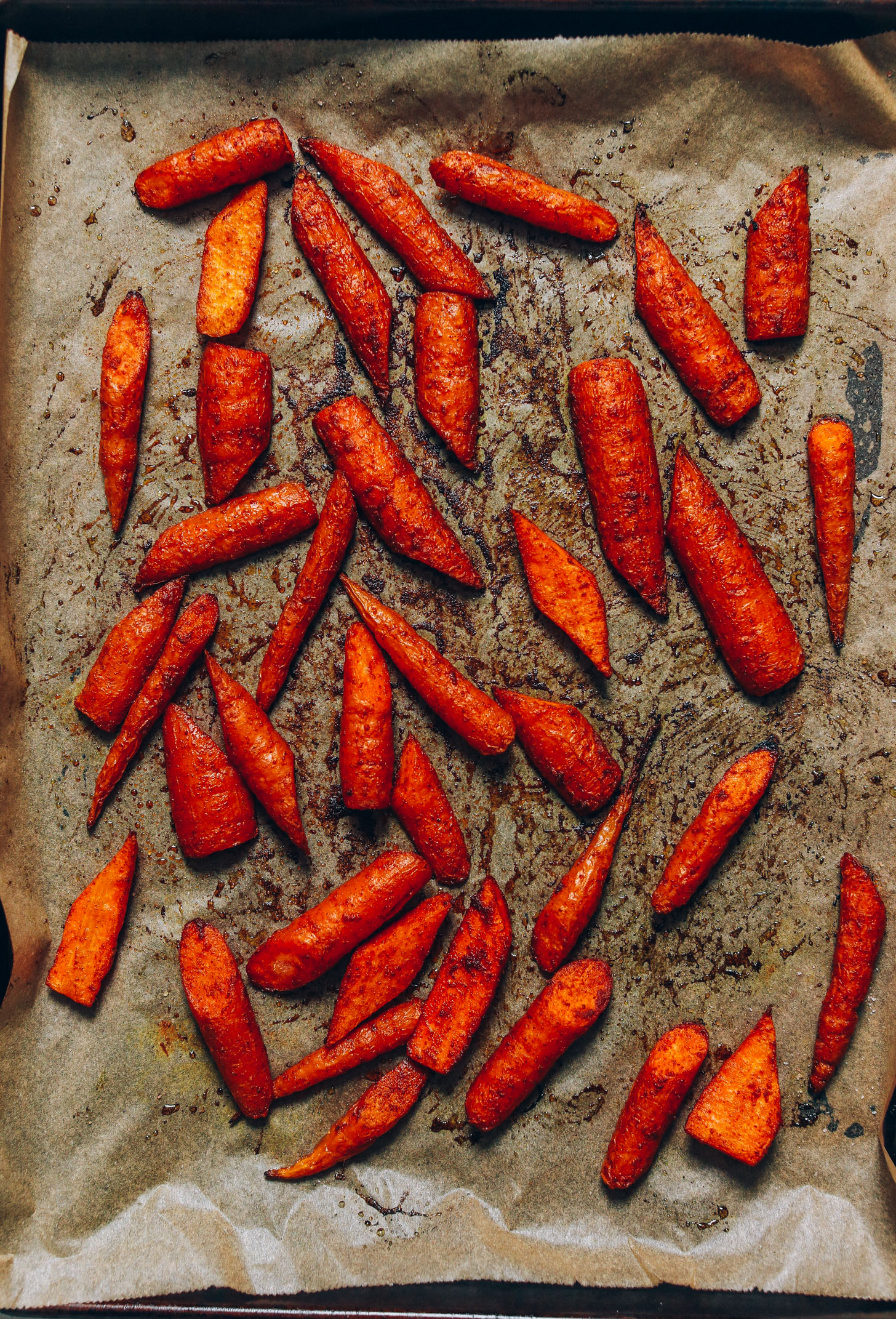 Perfectly roasted carrots on a parchment-lined baking sheet