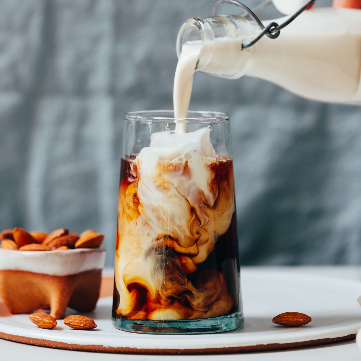 Pouring homemade coffee creamer into an iced coffee