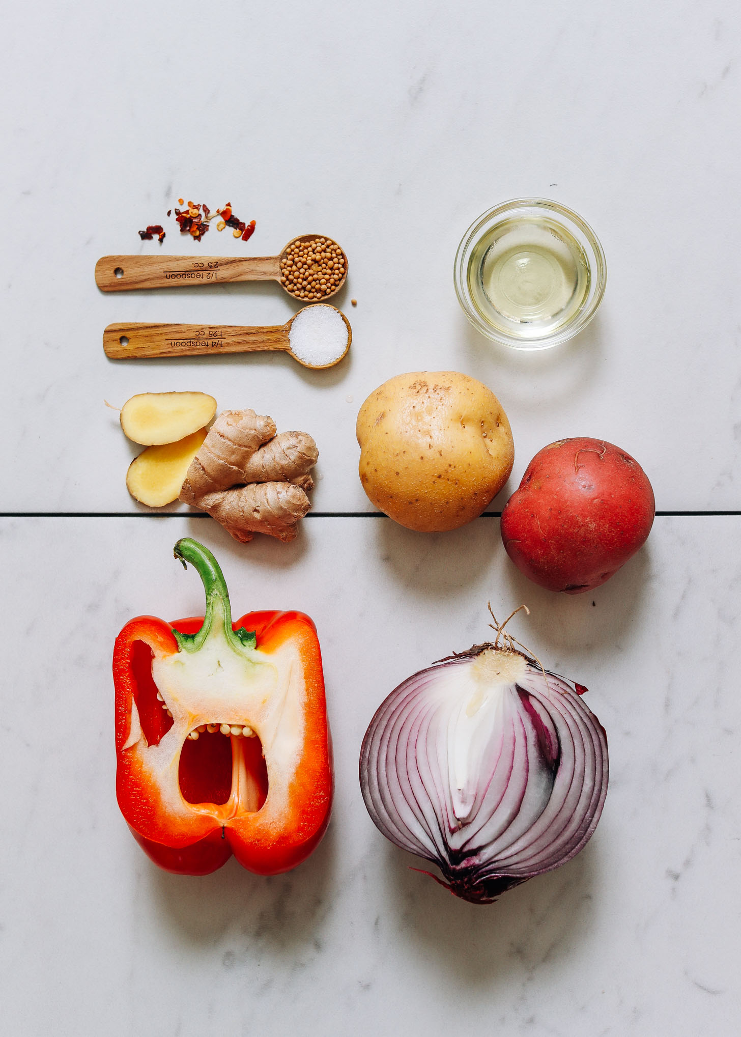 Red bell pepper, onion, potatoes, ginger, avocado oil, and spices for making our Indian-Inspired Potato Aloo Sabzi recipe